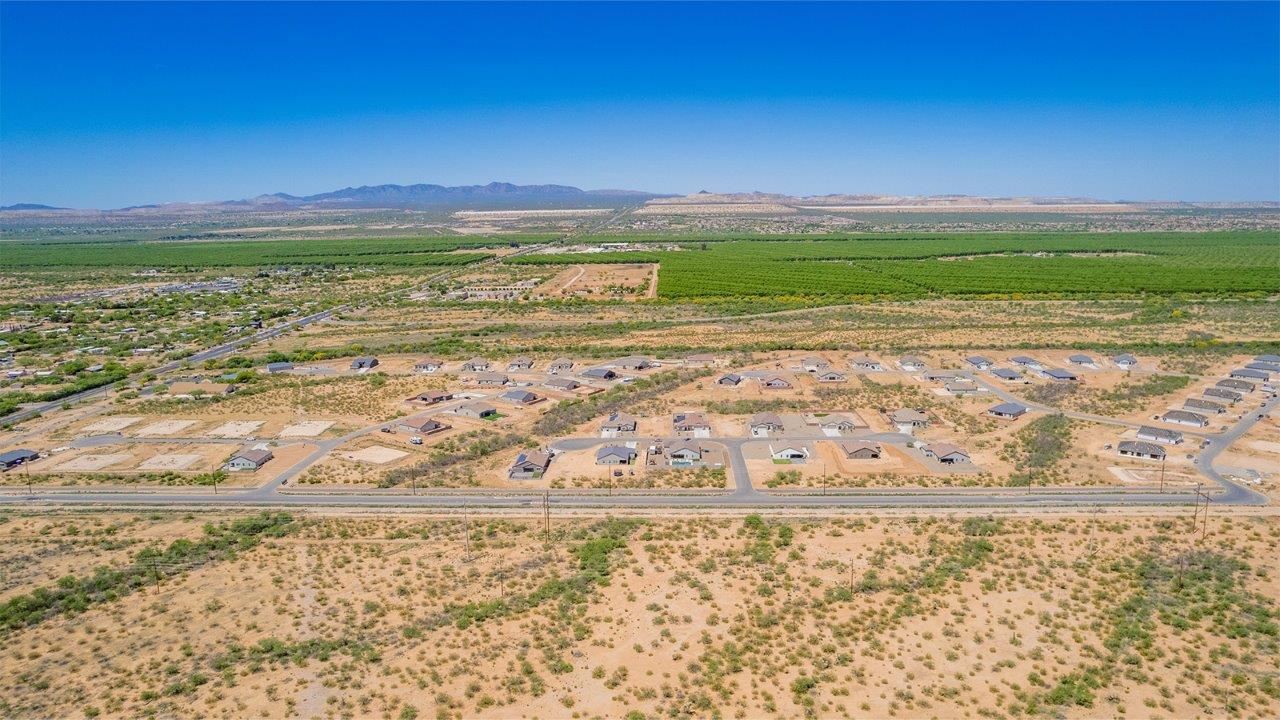 Welcome to The Madera, a beautifully expansive single-story new home nestled in the peaceful Sahuarita Acres community. With 2,131 square feet of thoughtfully arranged living space, this residence offers five bedrooms and three bathrooms, making it an exceptional choice for those who seek both comfort and versatility.  The journey through The Madera begins as you step onto the inviting front porch and enter through the welcoming foyer. The open layout immediately draws you into the spacious great room, where large windows allow natural light to fill the space, creating a warm and inviting atmosphere. The adjacent dining area flows seamlessly into the kitchen, which features a central island, quartz countertops, and 42” upper cabinets for ample storage. A walk-in pantry ensures that the kitchen remains both functional and stylish.  The Madera’s floor plan is designed with privacy in mind. The primary bedroom, located in a separate wing of the home, offers a large walk-in closet and an en-suite bathroom with dual sinks and a luxurious shower. On the opposite side of the home, four additional bedrooms are well-positioned to offer both privacy and easy access to the other two bathrooms, making this layout perfect for families or hosting guests.  One of the standout features of The Madera is its adaptability. The three-car garage and expansive near one-acre lots provide plenty of room for parking, storage, and outdoor activities, whether you envision creating a lush garden, installing a pool, or simply enjoying the vast open space.  For those who value modern conveniences, The Madera is equipped with D.R. Horton’s Home is Connected® Smart Home package, which includes a smart thermostat, video doorbell, keyless entry, a Wi-Fi-enabled garage door opener and more. Additionally, the home is built with energy efficiency in mind, featuring spray foam insulation and meeting DOE Zero Energy Ready Home standards, ensuring long-term savings and environmental benefits.  Located within the serene and spacious Sahuarita Acres community, residents of The Madera enjoy the perfect blend of small-town charm and modern amenities. With easy access to urban conveniences, excellent schools, and outdoor recreation opportunities, The Madera offers a lifestyle that embraces the essence of Arizona living.