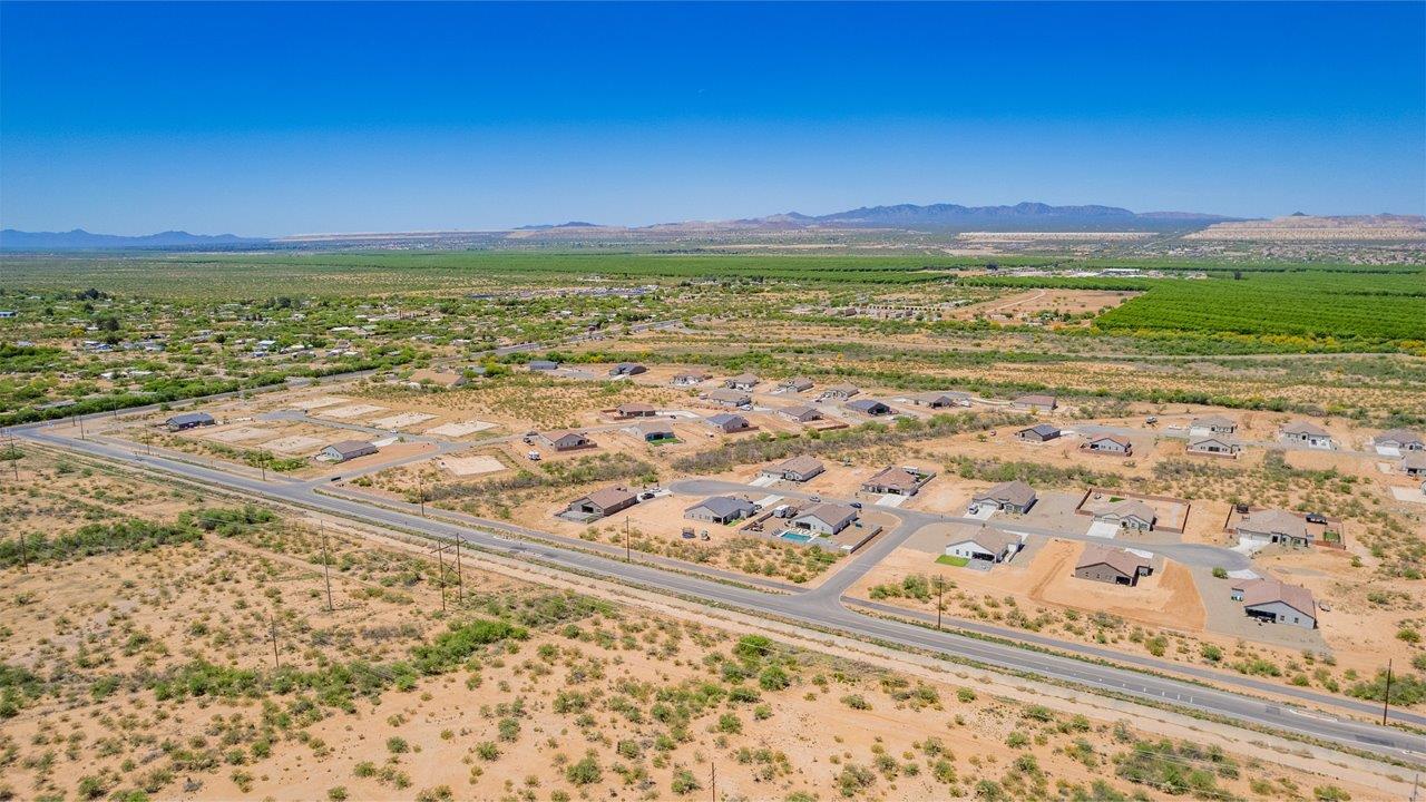 Welcome to The Madera, a beautifully expansive single-story new home nestled in the peaceful Sahuarita Acres community. With 2,131 square feet of thoughtfully arranged living space, this residence offers five bedrooms and three bathrooms, making it an exceptional choice for those who seek both comfort and versatility.  The journey through The Madera begins as you step onto the inviting front porch and enter through the welcoming foyer. The open layout immediately draws you into the spacious great room, where large windows allow natural light to fill the space, creating a warm and inviting atmosphere. The adjacent dining area flows seamlessly into the kitchen, which features a central island, quartz countertops, and 42” upper cabinets for ample storage. A walk-in pantry ensures that the kitchen remains both functional and stylish.  The Madera’s floor plan is designed with privacy in mind. The primary bedroom, located in a separate wing of the home, offers a large walk-in closet and an en-suite bathroom with dual sinks and a luxurious shower. On the opposite side of the home, four additional bedrooms are well-positioned to offer both privacy and easy access to the other two bathrooms, making this layout perfect for families or hosting guests.  One of the standout features of The Madera is its adaptability. The three-car garage and expansive near one-acre lots provide plenty of room for parking, storage, and outdoor activities, whether you envision creating a lush garden, installing a pool, or simply enjoying the vast open space.  For those who value modern conveniences, The Madera is equipped with D.R. Horton’s Home is Connected® Smart Home package, which includes a smart thermostat, video doorbell, keyless entry, a Wi-Fi-enabled garage door opener and more. Additionally, the home is built with energy efficiency in mind, featuring spray foam insulation and meeting DOE Zero Energy Ready Home standards, ensuring long-term savings and environmental benefits.  Located within the serene and spacious Sahuarita Acres community, residents of The Madera enjoy the perfect blend of small-town charm and modern amenities. With easy access to urban conveniences, excellent schools, and outdoor recreation opportunities, The Madera offers a lifestyle that embraces the essence of Arizona living.