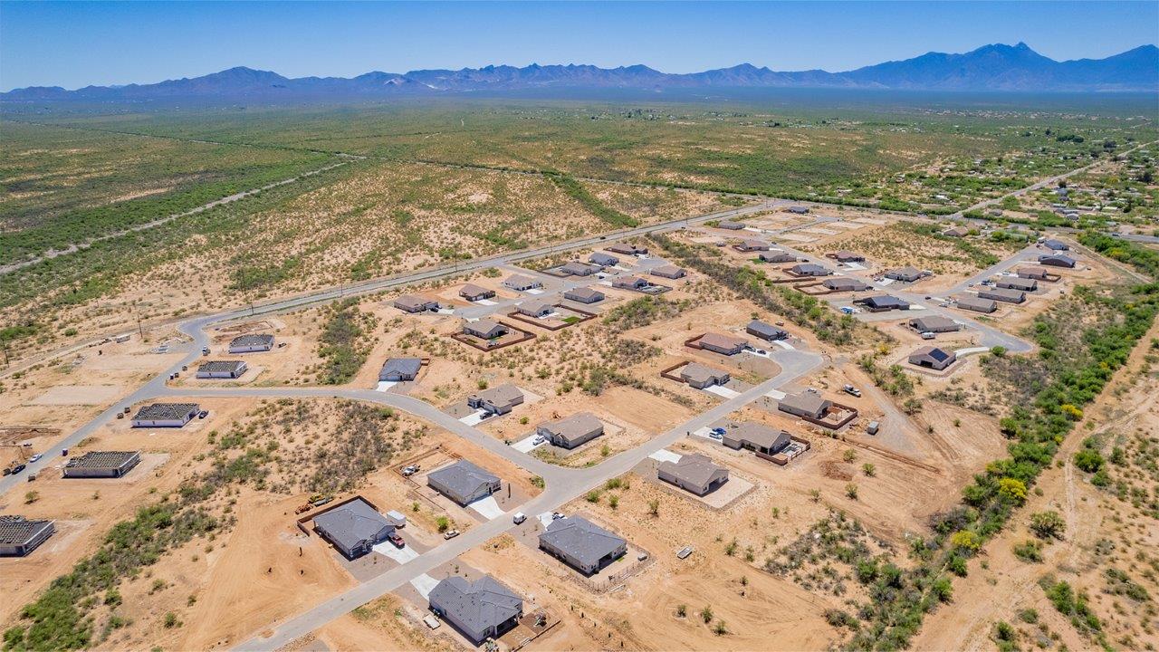 Welcome to The Madera, a beautifully expansive single-story new home nestled in the peaceful Sahuarita Acres community. With 2,131 square feet of thoughtfully arranged living space, this residence offers five bedrooms and three bathrooms, making it an exceptional choice for those who seek both comfort and versatility.  The journey through The Madera begins as you step onto the inviting front porch and enter through the welcoming foyer. The open layout immediately draws you into the spacious great room, where large windows allow natural light to fill the space, creating a warm and inviting atmosphere. The adjacent dining area flows seamlessly into the kitchen, which features a central island, quartz countertops, and 42” upper cabinets for ample storage. A walk-in pantry ensures that the kitchen remains both functional and stylish.  The Madera’s floor plan is designed with privacy in mind. The primary bedroom, located in a separate wing of the home, offers a large walk-in closet and an en-suite bathroom with dual sinks and a luxurious shower. On the opposite side of the home, four additional bedrooms are well-positioned to offer both privacy and easy access to the other two bathrooms, making this layout perfect for families or hosting guests.  One of the standout features of The Madera is its adaptability. The three-car garage and expansive near one-acre lots provide plenty of room for parking, storage, and outdoor activities, whether you envision creating a lush garden, installing a pool, or simply enjoying the vast open space.  For those who value modern conveniences, The Madera is equipped with D.R. Horton’s Home is Connected® Smart Home package, which includes a smart thermostat, video doorbell, keyless entry, a Wi-Fi-enabled garage door opener and more. Additionally, the home is built with energy efficiency in mind, featuring spray foam insulation and meeting DOE Zero Energy Ready Home standards, ensuring long-term savings and environmental benefits.  Located within the serene and spacious Sahuarita Acres community, residents of The Madera enjoy the perfect blend of small-town charm and modern amenities. With easy access to urban conveniences, excellent schools, and outdoor recreation opportunities, The Madera offers a lifestyle that embraces the essence of Arizona living.