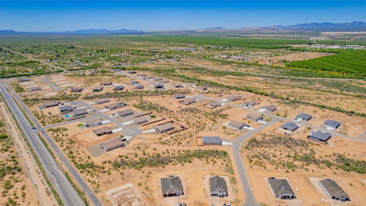 Welcome to The Madera, a beautifully expansive single-story new home nestled in the peaceful Sahuarita Acres community. With 2,131 square feet of thoughtfully arranged living space, this residence offers five bedrooms and three bathrooms, making it an exceptional choice for those who seek both comfort and versatility.  The journey through The Madera begins as you step onto the inviting front porch and enter through the welcoming foyer. The open layout immediately draws you into the spacious great room, where large windows allow natural light to fill the space, creating a warm and inviting atmosphere. The adjacent dining area flows seamlessly into the kitchen, which features a central island, quartz countertops, and 42” upper cabinets for ample storage. A walk-in pantry ensures that the kitchen remains both functional and stylish.  The Madera’s floor plan is designed with privacy in mind. The primary bedroom, located in a separate wing of the home, offers a large walk-in closet and an en-suite bathroom with dual sinks and a luxurious shower. On the opposite side of the home, four additional bedrooms are well-positioned to offer both privacy and easy access to the other two bathrooms, making this layout perfect for families or hosting guests.  One of the standout features of The Madera is its adaptability. The three-car garage and expansive near one-acre lots provide plenty of room for parking, storage, and outdoor activities, whether you envision creating a lush garden, installing a pool, or simply enjoying the vast open space.  For those who value modern conveniences, The Madera is equipped with D.R. Horton’s Home is Connected® Smart Home package, which includes a smart thermostat, video doorbell, keyless entry, a Wi-Fi-enabled garage door opener and more. Additionally, the home is built with energy efficiency in mind, featuring spray foam insulation and meeting DOE Zero Energy Ready Home standards, ensuring long-term savings and environmental benefits.  Located within the serene and spacious Sahuarita Acres community, residents of The Madera enjoy the perfect blend of small-town charm and modern amenities. With easy access to urban conveniences, excellent schools, and outdoor recreation opportunities, The Madera offers a lifestyle that embraces the essence of Arizona living.