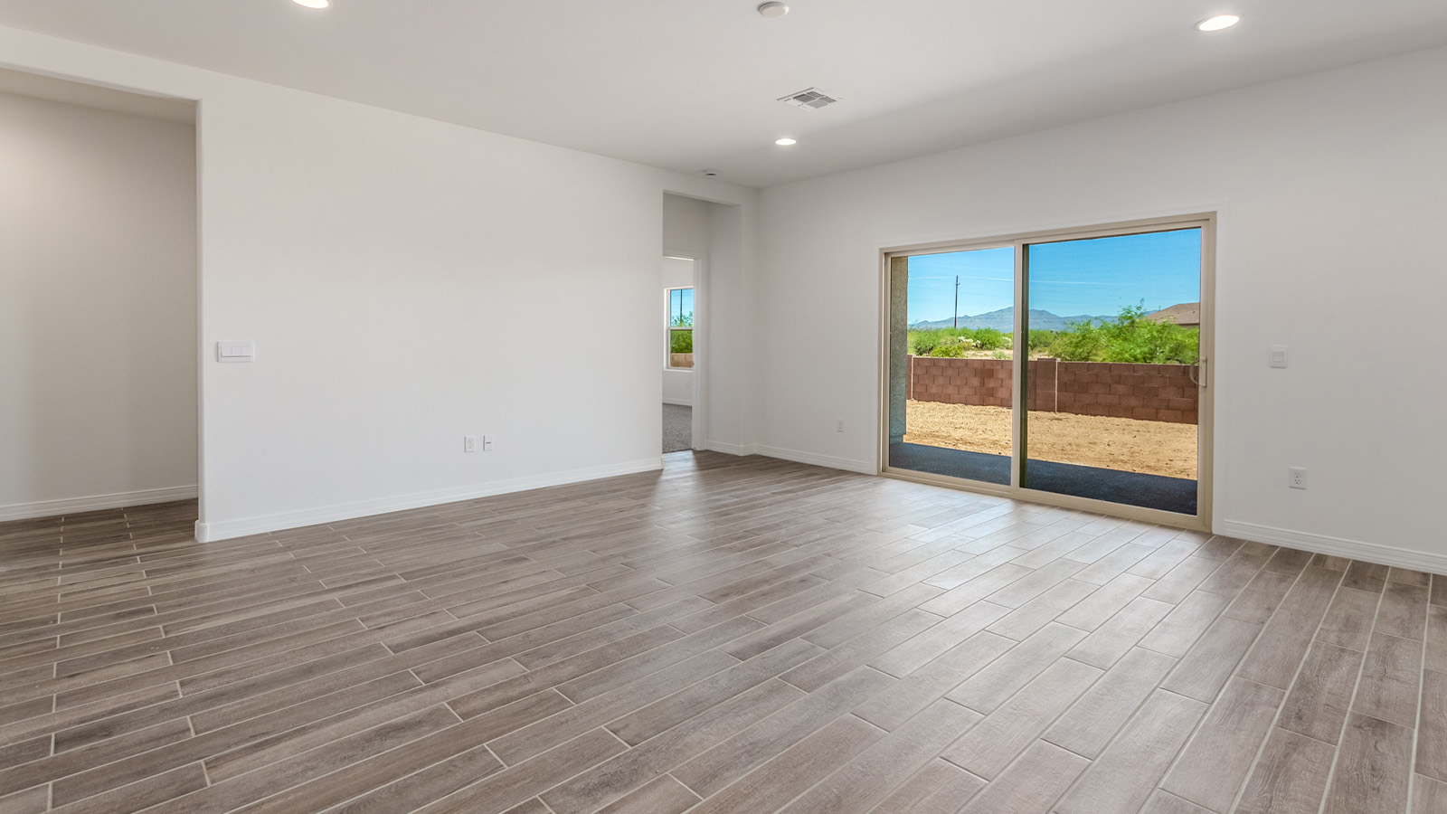 Introducing The Catalina, an expansive single-story home set in the serene and spacious Sahuarita Acres community. Covering 2,392 square feet, this residence offers four bedrooms and three bathrooms, perfectly balancing space and functionality for modern family living.  As you step into The Catalina, the entryway opens up to reveal a generous dining room that leads directly into the heart of the home—the great room. This central living space is designed for both relaxation and entertainment, with large windows that invite abundant natural light. The adjoining kitchen, complete with a large island, quartz countertops, and 42” upper cabinets, is as practical as it is stylish. A walk-in pantry provides ample storage, ensuring that everything you need is at your fingertips.  The primary bedroom, located in its own private wing, features a spacious walk-in closet and an en-suite bathroom equipped with dual sinks and a luxurious shower, offering a perfect space for winding down after a busy day. The additional three bedrooms are well-spaced throughout the home, each offering easy access to one of the two additional bathrooms, making it ideal for family living or hosting guests.  One of the standout features of The Catalina is its seamless blend of indoor and outdoor living. The covered patio, accessible from the great room, is an ideal spot for outdoor dining or simply enjoying the expansive one-acre lot that comes with each home in Sahuarita Acres. Whether you envision a garden, a play area, or even a pool, the possibilities are endless with the amount of outdoor space available.  The Catalina also includes a three-car garage and ample driveway space, perfect for parking vehicles, RVs, or additional storage. With D.R. Horton’s Home is Connected® Smart Home package, this home ensures you stay connected and secure, featuring a smart thermostat, video doorbell, keyless entry, a Wi-Fi-enabled garage door opener, and more.  Built with energy efficiency in mind, The Catalina features spray foam insulation and meets DOE Zero Energy Ready Home standards, helping you save on energy costs while contributing to a greener environment.  Nestled in the tranquil Sahuarita Acres community, residents enjoy the best of both worlds—peaceful, spacious living with easy access to urban amenities and outdoor recreation. With its combination of modern conveniences, thoughtful design, and expansive lots, The Catalina offers a lifestyle that truly captures the essence of Arizona living.