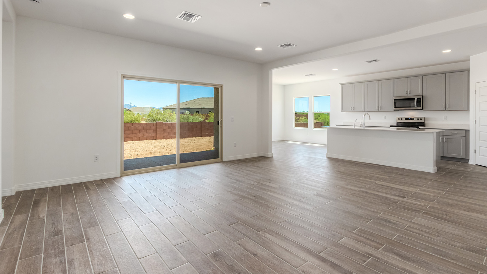 Introducing The Catalina, an expansive single-story home set in the serene and spacious Sahuarita Acres community. Covering 2,392 square feet, this residence offers four bedrooms and three bathrooms, perfectly balancing space and functionality for modern family living.  As you step into The Catalina, the entryway opens up to reveal a generous dining room that leads directly into the heart of the home—the great room. This central living space is designed for both relaxation and entertainment, with large windows that invite abundant natural light. The adjoining kitchen, complete with a large island, quartz countertops, and 42” upper cabinets, is as practical as it is stylish. A walk-in pantry provides ample storage, ensuring that everything you need is at your fingertips.  The primary bedroom, located in its own private wing, features a spacious walk-in closet and an en-suite bathroom equipped with dual sinks and a luxurious shower, offering a perfect space for winding down after a busy day. The additional three bedrooms are well-spaced throughout the home, each offering easy access to one of the two additional bathrooms, making it ideal for family living or hosting guests.  One of the standout features of The Catalina is its seamless blend of indoor and outdoor living. The covered patio, accessible from the great room, is an ideal spot for outdoor dining or simply enjoying the expansive one-acre lot that comes with each home in Sahuarita Acres. Whether you envision a garden, a play area, or even a pool, the possibilities are endless with the amount of outdoor space available.  The Catalina also includes a three-car garage and ample driveway space, perfect for parking vehicles, RVs, or additional storage. With D.R. Horton’s Home is Connected® Smart Home package, this home ensures you stay connected and secure, featuring a smart thermostat, video doorbell, keyless entry, a Wi-Fi-enabled garage door opener, and more.  Built with energy efficiency in mind, The Catalina features spray foam insulation and meets DOE Zero Energy Ready Home standards, helping you save on energy costs while contributing to a greener environment.  Nestled in the tranquil Sahuarita Acres community, residents enjoy the best of both worlds—peaceful, spacious living with easy access to urban amenities and outdoor recreation. With its combination of modern conveniences, thoughtful design, and expansive lots, The Catalina offers a lifestyle that truly captures the essence of Arizona living.