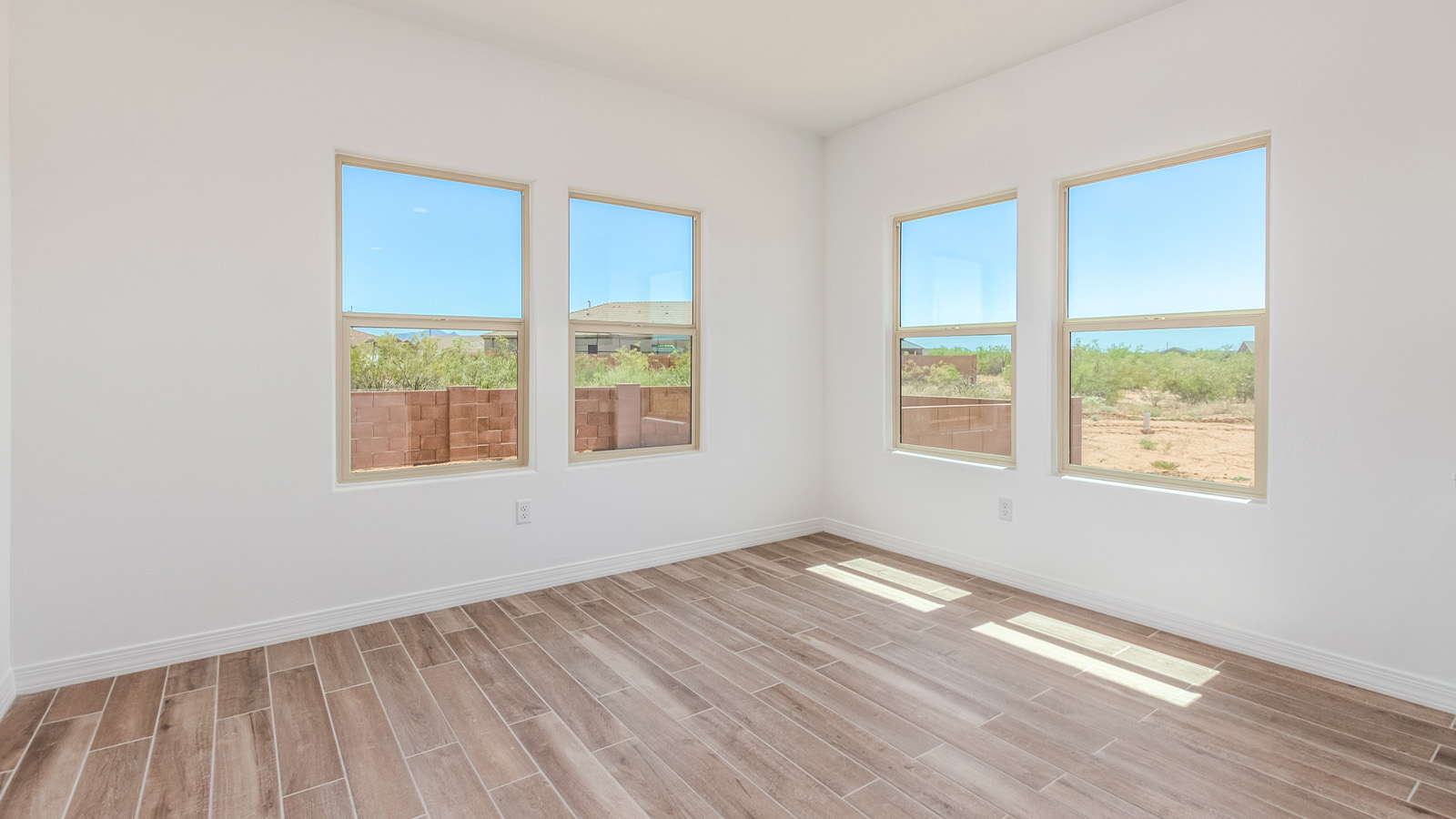 Introducing The Catalina, an expansive single-story home set in the serene and spacious Sahuarita Acres community. Covering 2,392 square feet, this residence offers four bedrooms and three bathrooms, perfectly balancing space and functionality for modern family living.  As you step into The Catalina, the entryway opens up to reveal a generous dining room that leads directly into the heart of the home—the great room. This central living space is designed for both relaxation and entertainment, with large windows that invite abundant natural light. The adjoining kitchen, complete with a large island, quartz countertops, and 42” upper cabinets, is as practical as it is stylish. A walk-in pantry provides ample storage, ensuring that everything you need is at your fingertips.  The primary bedroom, located in its own private wing, features a spacious walk-in closet and an en-suite bathroom equipped with dual sinks and a luxurious shower, offering a perfect space for winding down after a busy day. The additional three bedrooms are well-spaced throughout the home, each offering easy access to one of the two additional bathrooms, making it ideal for family living or hosting guests.  One of the standout features of The Catalina is its seamless blend of indoor and outdoor living. The covered patio, accessible from the great room, is an ideal spot for outdoor dining or simply enjoying the expansive one-acre lot that comes with each home in Sahuarita Acres. Whether you envision a garden, a play area, or even a pool, the possibilities are endless with the amount of outdoor space available.  The Catalina also includes a three-car garage and ample driveway space, perfect for parking vehicles, RVs, or additional storage. With D.R. Horton’s Home is Connected® Smart Home package, this home ensures you stay connected and secure, featuring a smart thermostat, video doorbell, keyless entry, a Wi-Fi-enabled garage door opener, and more.  Built with energy efficiency in mind, The Catalina features spray foam insulation and meets DOE Zero Energy Ready Home standards, helping you save on energy costs while contributing to a greener environment.  Nestled in the tranquil Sahuarita Acres community, residents enjoy the best of both worlds—peaceful, spacious living with easy access to urban amenities and outdoor recreation. With its combination of modern conveniences, thoughtful design, and expansive lots, The Catalina offers a lifestyle that truly captures the essence of Arizona living.