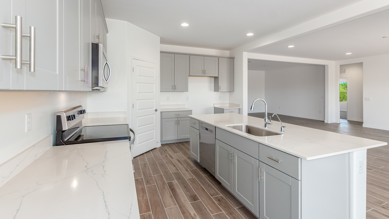 Introducing The Catalina, an expansive single-story home set in the serene and spacious Sahuarita Acres community. Covering 2,392 square feet, this residence offers four bedrooms and three bathrooms, perfectly balancing space and functionality for modern family living.  As you step into The Catalina, the entryway opens up to reveal a generous dining room that leads directly into the heart of the home—the great room. This central living space is designed for both relaxation and entertainment, with large windows that invite abundant natural light. The adjoining kitchen, complete with a large island, quartz countertops, and 42” upper cabinets, is as practical as it is stylish. A walk-in pantry provides ample storage, ensuring that everything you need is at your fingertips.  The primary bedroom, located in its own private wing, features a spacious walk-in closet and an en-suite bathroom equipped with dual sinks and a luxurious shower, offering a perfect space for winding down after a busy day. The additional three bedrooms are well-spaced throughout the home, each offering easy access to one of the two additional bathrooms, making it ideal for family living or hosting guests.  One of the standout features of The Catalina is its seamless blend of indoor and outdoor living. The covered patio, accessible from the great room, is an ideal spot for outdoor dining or simply enjoying the expansive one-acre lot that comes with each home in Sahuarita Acres. Whether you envision a garden, a play area, or even a pool, the possibilities are endless with the amount of outdoor space available.  The Catalina also includes a three-car garage and ample driveway space, perfect for parking vehicles, RVs, or additional storage. With D.R. Horton’s Home is Connected® Smart Home package, this home ensures you stay connected and secure, featuring a smart thermostat, video doorbell, keyless entry, a Wi-Fi-enabled garage door opener, and more.  Built with energy efficiency in mind, The Catalina features spray foam insulation and meets DOE Zero Energy Ready Home standards, helping you save on energy costs while contributing to a greener environment.  Nestled in the tranquil Sahuarita Acres community, residents enjoy the best of both worlds—peaceful, spacious living with easy access to urban amenities and outdoor recreation. With its combination of modern conveniences, thoughtful design, and expansive lots, The Catalina offers a lifestyle that truly captures the essence of Arizona living.