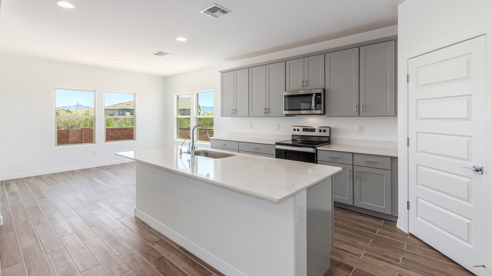 Introducing The Catalina, an expansive single-story home set in the serene and spacious Sahuarita Acres community. Covering 2,392 square feet, this residence offers four bedrooms and three bathrooms, perfectly balancing space and functionality for modern family living.  As you step into The Catalina, the entryway opens up to reveal a generous dining room that leads directly into the heart of the home—the great room. This central living space is designed for both relaxation and entertainment, with large windows that invite abundant natural light. The adjoining kitchen, complete with a large island, quartz countertops, and 42” upper cabinets, is as practical as it is stylish. A walk-in pantry provides ample storage, ensuring that everything you need is at your fingertips.  The primary bedroom, located in its own private wing, features a spacious walk-in closet and an en-suite bathroom equipped with dual sinks and a luxurious shower, offering a perfect space for winding down after a busy day. The additional three bedrooms are well-spaced throughout the home, each offering easy access to one of the two additional bathrooms, making it ideal for family living or hosting guests.  One of the standout features of The Catalina is its seamless blend of indoor and outdoor living. The covered patio, accessible from the great room, is an ideal spot for outdoor dining or simply enjoying the expansive one-acre lot that comes with each home in Sahuarita Acres. Whether you envision a garden, a play area, or even a pool, the possibilities are endless with the amount of outdoor space available.  The Catalina also includes a three-car garage and ample driveway space, perfect for parking vehicles, RVs, or additional storage. With D.R. Horton’s Home is Connected® Smart Home package, this home ensures you stay connected and secure, featuring a smart thermostat, video doorbell, keyless entry, a Wi-Fi-enabled garage door opener, and more.  Built with energy efficiency in mind, The Catalina features spray foam insulation and meets DOE Zero Energy Ready Home standards, helping you save on energy costs while contributing to a greener environment.  Nestled in the tranquil Sahuarita Acres community, residents enjoy the best of both worlds—peaceful, spacious living with easy access to urban amenities and outdoor recreation. With its combination of modern conveniences, thoughtful design, and expansive lots, The Catalina offers a lifestyle that truly captures the essence of Arizona living.