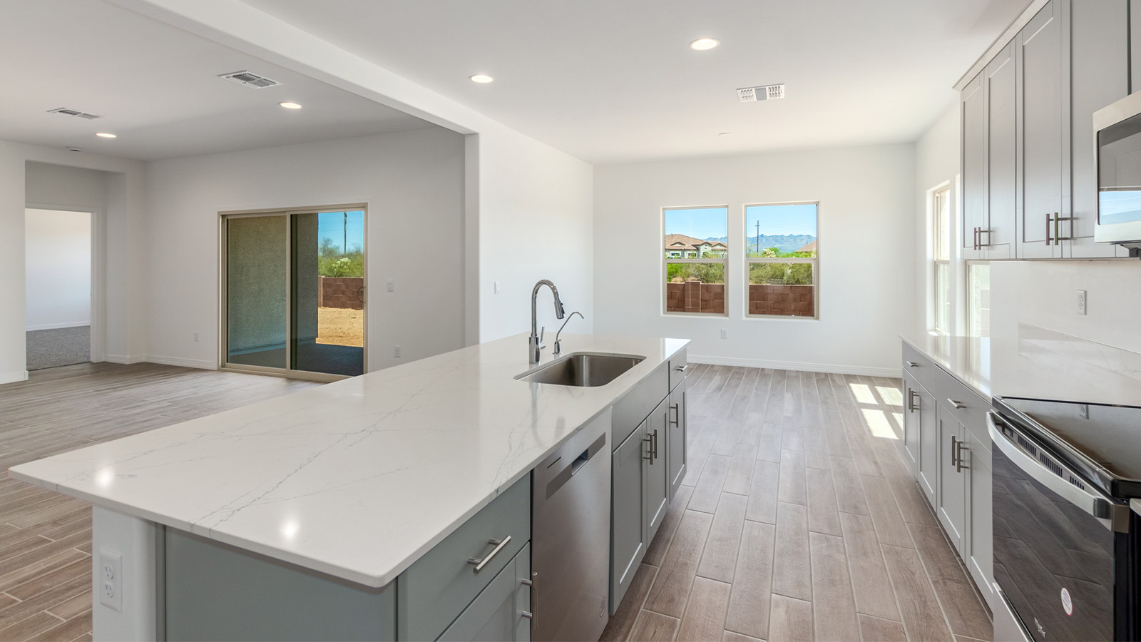 Introducing The Catalina, an expansive single-story home set in the serene and spacious Sahuarita Acres community. Covering 2,392 square feet, this residence offers four bedrooms and three bathrooms, perfectly balancing space and functionality for modern family living.  As you step into The Catalina, the entryway opens up to reveal a generous dining room that leads directly into the heart of the home—the great room. This central living space is designed for both relaxation and entertainment, with large windows that invite abundant natural light. The adjoining kitchen, complete with a large island, quartz countertops, and 42” upper cabinets, is as practical as it is stylish. A walk-in pantry provides ample storage, ensuring that everything you need is at your fingertips.  The primary bedroom, located in its own private wing, features a spacious walk-in closet and an en-suite bathroom equipped with dual sinks and a luxurious shower, offering a perfect space for winding down after a busy day. The additional three bedrooms are well-spaced throughout the home, each offering easy access to one of the two additional bathrooms, making it ideal for family living or hosting guests.  One of the standout features of The Catalina is its seamless blend of indoor and outdoor living. The covered patio, accessible from the great room, is an ideal spot for outdoor dining or simply enjoying the expansive one-acre lot that comes with each home in Sahuarita Acres. Whether you envision a garden, a play area, or even a pool, the possibilities are endless with the amount of outdoor space available.  The Catalina also includes a three-car garage and ample driveway space, perfect for parking vehicles, RVs, or additional storage. With D.R. Horton’s Home is Connected® Smart Home package, this home ensures you stay connected and secure, featuring a smart thermostat, video doorbell, keyless entry, a Wi-Fi-enabled garage door opener, and more.  Built with energy efficiency in mind, The Catalina features spray foam insulation and meets DOE Zero Energy Ready Home standards, helping you save on energy costs while contributing to a greener environment.  Nestled in the tranquil Sahuarita Acres community, residents enjoy the best of both worlds—peaceful, spacious living with easy access to urban amenities and outdoor recreation. With its combination of modern conveniences, thoughtful design, and expansive lots, The Catalina offers a lifestyle that truly captures the essence of Arizona living.