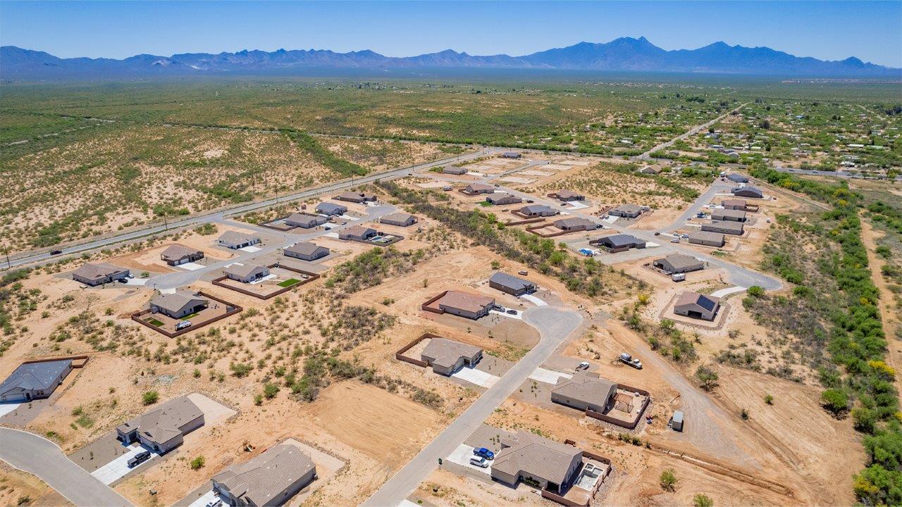 Introducing The Cali, a charming single-story new home located in the expansive Sahuarita Acres community. Covering 1,823 square feet, this home offers four bedrooms and two bathrooms, making it an excellent choice for families seeking both space and modern comfort.  As you step through the front porch and into the welcoming entryway, you’re immediately led into the heart of the home. The open-concept great room seamlessly connects to the dining area and kitchen, creating a perfect space for gathering with family and friends. The kitchen is a standout feature, boasting a central island, sleek granite countertops, and stylish 42” upper cabinets that offer ample storage. A spacious pantry adds to the kitchen’s functionality, ensuring everything you need is within reach.  The Cali’s layout is thoughtfully designed to maximize privacy and comfort. The primary bedroom, located at the rear of the home, features a large walk-in closet and an en-suite bathroom with dual sinks, providing a private space to start and end your day. The additional three bedrooms are situated toward the front of the home, each offering plenty of closet space and easy access to a full bathroom, making this layout ideal for families or guests.  One of the highlights of The Cali is the outdoor living space. The covered patio extends from the great room, offering an ideal spot to enjoy the expansive near one-acre lots that Sahuarita Acres is known for. Whether you’re planning to create a dream outdoor oasis or simply enjoy the natural surroundings, this space offers endless possibilities.  Built with modern living in mind, The Cali includes D.R. Horton’s Home is Connected® Smart Home package, featuring a smart thermostat, video doorbell, keyless entry, and a Wi-Fi-enabled garage door opener. Energy efficiency is also a priority, with spray foam insulation and designs that meet the DOE Zero Energy Ready Home standards, ensuring long-term savings and environmental benefits.  Located within the serene Sahuarita Acres community, residents of The Cali enjoy the luxury of space combined with easy access to urban amenities. With a three-car garage and RV parking on a 30’ driveway, this home is designed to accommodate your lifestyle while offering a peaceful retreat from the hustle and bustle.  Come home to The Cali, where comfort, style, and the beauty of Arizona living come together in perfect harmony.
