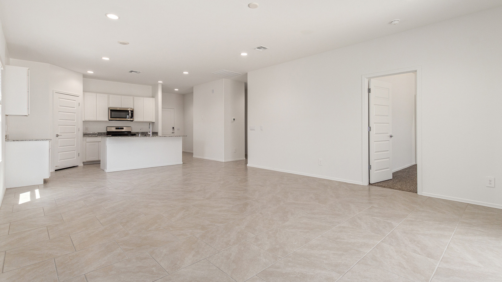 Step into The Elgin, a spacious single-story home located in the scenic Sycamore Vista community in Vail, AZ. This floor plan offers 1,635 square feet of well-planned living space, perfect for those who appreciate both comfort and functionality. With four bedrooms, two bathrooms, and a 3-car garage, The Elgin provides the ideal setting for modern living amidst the beauty of the Santa Rita Mountains.  As you enter through the inviting front porch, you’re welcomed by an open and airy floor plan that flows effortlessly from one room to the next. The heart of the home is the expansive great room, seamlessly connected to the dining area and kitchen, making it ideal for everyday living and entertaining. The kitchen is a chef’s delight, featuring a large island with a breakfast bar, granite countertops, and Shaker-style cabinetry, offering ample storage and workspace. The walk-in pantry and adjacent utility room add convenience and organization to your culinary adventures.  The primary suite is designed with relaxation in mind, offering a spacious bedroom with a walk-in closet and a private en-suite bathroom. This personal haven is positioned at the rear of the home for added privacy. The three additional bedrooms are located towards the front of the home, providing flexibility for guests, family, or a home office setup. A second full bathroom is conveniently situated near these bedrooms.  One of the standout features of The Elgin is the 3-car garage, providing plenty of room for vehicles, storage, or even a workshop. Whether you have multiple cars, recreational vehicles, or just need extra space, this garage has you covered.  Step outside to enjoy your covered patio, which is perfect for outdoor dining, lounging, or simply taking in the stunning Arizona sunsets. The large backyard provides endless possibilities for gardening, play, or creating your own outdoor oasis.  Living at Sycamore Vista means enjoying a community that balances modern amenities with natural beauty. Your home includes luxury finishes such as staggered wood-look ceramic tile flooring throughout most areas, granite countertops, and energy-efficient features like spray foam insulation and tankless water heaters. Additionally, each home in the community comes equipped with a Home is Connected® Smart Home package, offering conveniences like a smart thermostat, video doorbell, keyless entry, a wifi-enabled garage door opener and more.  Sycamore Vista’s prime location in the Vail School District makes it a great choice for families. With schools like Sycamore Elementary and Corona Foothills Middle School nearby, you’ll have peace of mind knowing your children are receiving a quality education. The community’s higher elevation offers cooler summer temperatures and spectacular night skies, making it a perfect spot for stargazing.  Experience the perfect blend of rural charm and modern convenience at Sycamore Vista, where The Elgin offers a space that’s more than just a house—it’s a home designed to grow with you and your family.