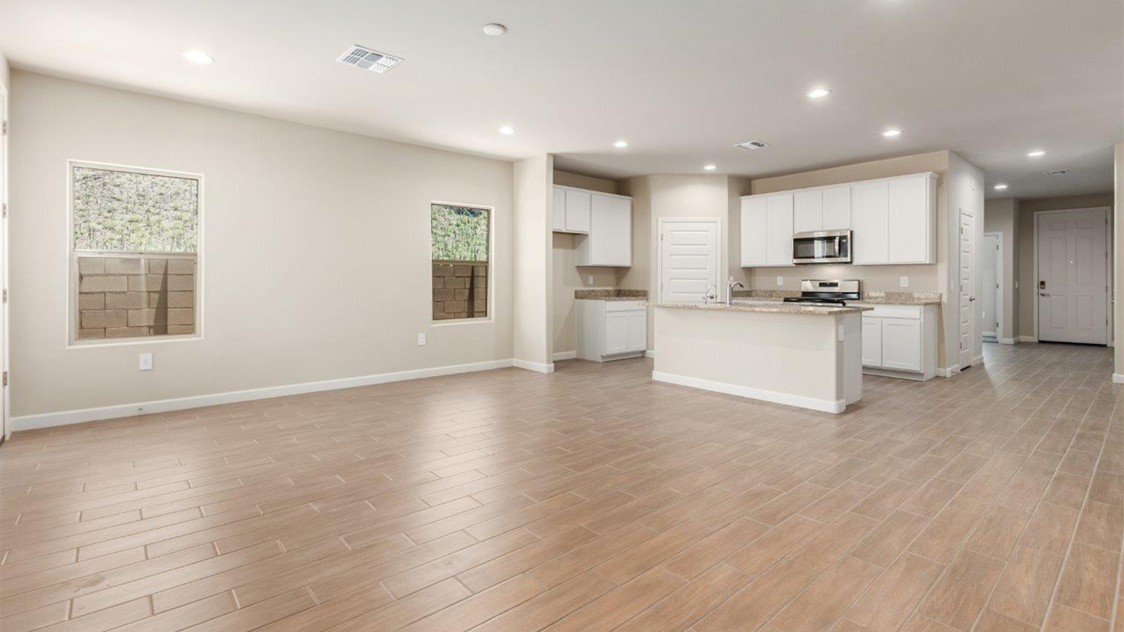 The Lakeway, situated within the beautiful Sycamore Vista community in Vail, Arizona, offers a perfect blend of functionality and comfort, ideal for both growing families and those who appreciate spacious living. With its 2,034 square feet of living space, this single-story new home features five bedrooms and three bathrooms, all meticulously designed to maximize space and convenience.  Entering The Lakeway, you’ll immediately notice the bright and airy atmosphere that flows through the open-concept floor plan. The heart of the home is the great room, seamlessly connected to the kitchen and dining area. The kitchen is equipped with quartz countertops, Shaker-style cabinetry, and a large island that serves as a focal point for both meal preparation and casual gatherings.  The primary bedroom is a true retreat, offering a spacious walk-in closet and an en-suite bathroom. The additional bedrooms are thoughtfully spaced to provide ample privacy for family members or guests, and the two secondary bathrooms are finished with modern fixtures and plenty of storage. This home offers a 2-3 car garage option for substantial space of vehicles and storage, accommodating the practical needs of busy households.  Standard features in The Lakeway at Sycamore Vista include energy-efficient elements like a tankless water heater, spray foam insulation, and LED lighting throughout. The home also comes with a Home is Connected® Smart Home package, which includes a smart thermostat, video doorbell, keyless entry, and more, ensuring modern conveniences are at your fingertips. The front yard is beautifully landscaped and includes an auto drip irrigation system, enhancing the curb appeal of this stunning home.  Nestled within Sycamore Vista, The Lakeway combines the tranquility of a rural setting with proximity to excellent schools, shopping, dining, and outdoor recreation, making it an exceptional place to call home.