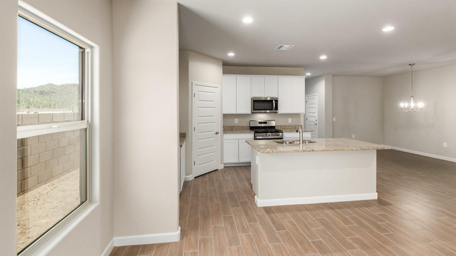 The Lakeway, situated within the beautiful Sycamore Vista community in Vail, Arizona, offers a perfect blend of functionality and comfort, ideal for both growing families and those who appreciate spacious living. With its 2,034 square feet of living space, this single-story new home features five bedrooms and three bathrooms, all meticulously designed to maximize space and convenience.  Entering The Lakeway, you’ll immediately notice the bright and airy atmosphere that flows through the open-concept floor plan. The heart of the home is the great room, seamlessly connected to the kitchen and dining area. The kitchen is equipped with quartz countertops, Shaker-style cabinetry, and a large island that serves as a focal point for both meal preparation and casual gatherings.  The primary bedroom is a true retreat, offering a spacious walk-in closet and an en-suite bathroom. The additional bedrooms are thoughtfully spaced to provide ample privacy for family members or guests, and the two secondary bathrooms are finished with modern fixtures and plenty of storage. This home offers a 2-3 car garage option for substantial space of vehicles and storage, accommodating the practical needs of busy households.  Standard features in The Lakeway at Sycamore Vista include energy-efficient elements like a tankless water heater, spray foam insulation, and LED lighting throughout. The home also comes with a Home is Connected® Smart Home package, which includes a smart thermostat, video doorbell, keyless entry, and more, ensuring modern conveniences are at your fingertips. The front yard is beautifully landscaped and includes an auto drip irrigation system, enhancing the curb appeal of this stunning home.  Nestled within Sycamore Vista, The Lakeway combines the tranquility of a rural setting with proximity to excellent schools, shopping, dining, and outdoor recreation, making it an exceptional place to call home.