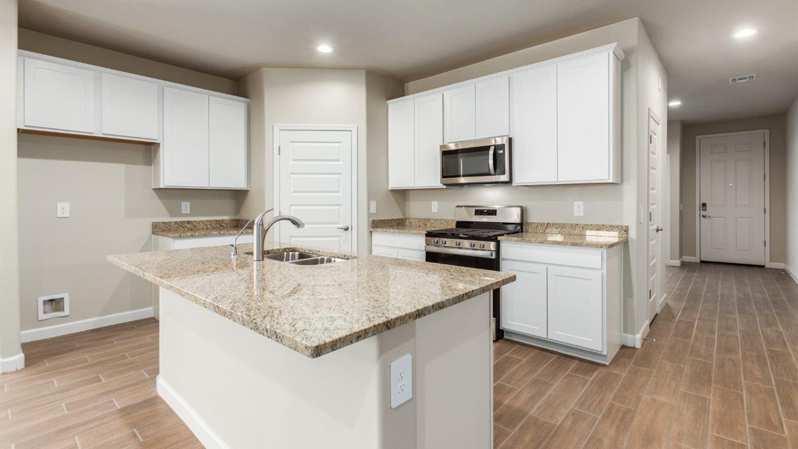 The Lakeway, situated within the beautiful Sycamore Vista community in Vail, Arizona, offers a perfect blend of functionality and comfort, ideal for both growing families and those who appreciate spacious living. With its 2,034 square feet of living space, this single-story new home features five bedrooms and three bathrooms, all meticulously designed to maximize space and convenience.  Entering The Lakeway, you’ll immediately notice the bright and airy atmosphere that flows through the open-concept floor plan. The heart of the home is the great room, seamlessly connected to the kitchen and dining area. The kitchen is equipped with quartz countertops, Shaker-style cabinetry, and a large island that serves as a focal point for both meal preparation and casual gatherings.  The primary bedroom is a true retreat, offering a spacious walk-in closet and an en-suite bathroom. The additional bedrooms are thoughtfully spaced to provide ample privacy for family members or guests, and the two secondary bathrooms are finished with modern fixtures and plenty of storage. This home offers a 2-3 car garage option for substantial space of vehicles and storage, accommodating the practical needs of busy households.  Standard features in The Lakeway at Sycamore Vista include energy-efficient elements like a tankless water heater, spray foam insulation, and LED lighting throughout. The home also comes with a Home is Connected® Smart Home package, which includes a smart thermostat, video doorbell, keyless entry, and more, ensuring modern conveniences are at your fingertips. The front yard is beautifully landscaped and includes an auto drip irrigation system, enhancing the curb appeal of this stunning home.  Nestled within Sycamore Vista, The Lakeway combines the tranquility of a rural setting with proximity to excellent schools, shopping, dining, and outdoor recreation, making it an exceptional place to call home.