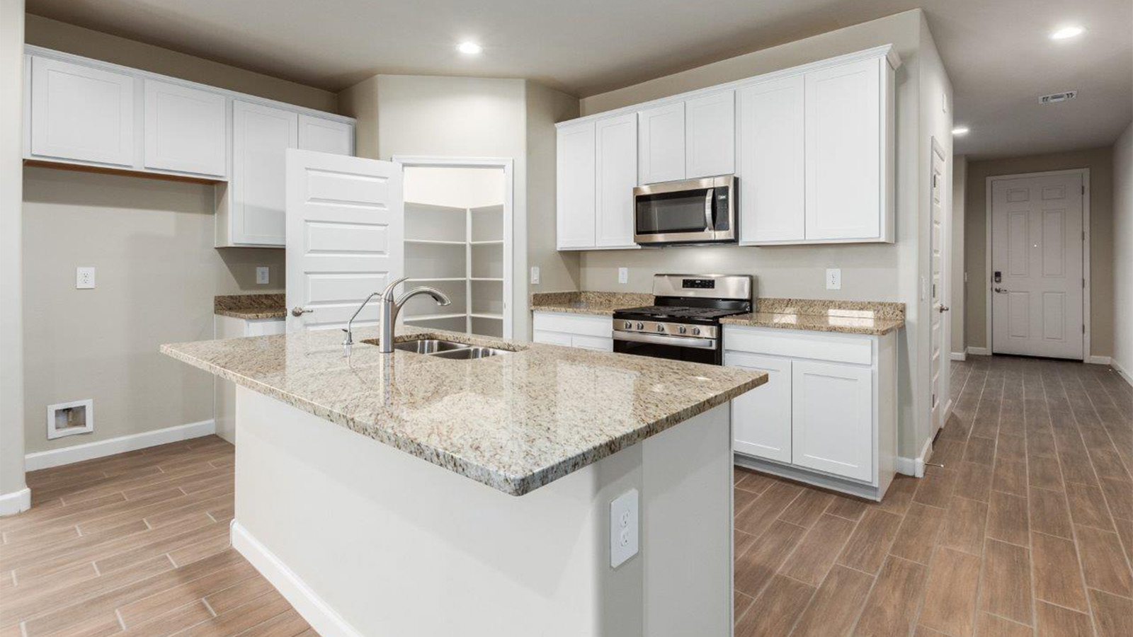 The Lakeway, situated within the beautiful Sycamore Vista community in Vail, Arizona, offers a perfect blend of functionality and comfort, ideal for both growing families and those who appreciate spacious living. With its 2,034 square feet of living space, this single-story new home features five bedrooms and three bathrooms, all meticulously designed to maximize space and convenience.  Entering The Lakeway, you’ll immediately notice the bright and airy atmosphere that flows through the open-concept floor plan. The heart of the home is the great room, seamlessly connected to the kitchen and dining area. The kitchen is equipped with quartz countertops, Shaker-style cabinetry, and a large island that serves as a focal point for both meal preparation and casual gatherings.  The primary bedroom is a true retreat, offering a spacious walk-in closet and an en-suite bathroom. The additional bedrooms are thoughtfully spaced to provide ample privacy for family members or guests, and the two secondary bathrooms are finished with modern fixtures and plenty of storage. This home offers a 2-3 car garage option for substantial space of vehicles and storage, accommodating the practical needs of busy households.  Standard features in The Lakeway at Sycamore Vista include energy-efficient elements like a tankless water heater, spray foam insulation, and LED lighting throughout. The home also comes with a Home is Connected® Smart Home package, which includes a smart thermostat, video doorbell, keyless entry, and more, ensuring modern conveniences are at your fingertips. The front yard is beautifully landscaped and includes an auto drip irrigation system, enhancing the curb appeal of this stunning home.  Nestled within Sycamore Vista, The Lakeway combines the tranquility of a rural setting with proximity to excellent schools, shopping, dining, and outdoor recreation, making it an exceptional place to call home.