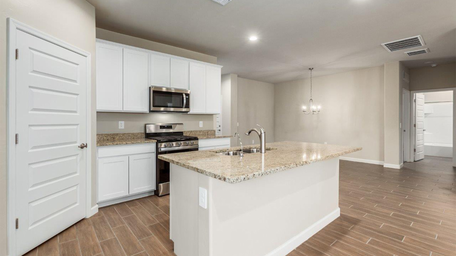 The Lakeway, situated within the beautiful Sycamore Vista community in Vail, Arizona, offers a perfect blend of functionality and comfort, ideal for both growing families and those who appreciate spacious living. With its 2,034 square feet of living space, this single-story new home features five bedrooms and three bathrooms, all meticulously designed to maximize space and convenience.  Entering The Lakeway, you’ll immediately notice the bright and airy atmosphere that flows through the open-concept floor plan. The heart of the home is the great room, seamlessly connected to the kitchen and dining area. The kitchen is equipped with quartz countertops, Shaker-style cabinetry, and a large island that serves as a focal point for both meal preparation and casual gatherings.  The primary bedroom is a true retreat, offering a spacious walk-in closet and an en-suite bathroom. The additional bedrooms are thoughtfully spaced to provide ample privacy for family members or guests, and the two secondary bathrooms are finished with modern fixtures and plenty of storage. This home offers a 2-3 car garage option for substantial space of vehicles and storage, accommodating the practical needs of busy households.  Standard features in The Lakeway at Sycamore Vista include energy-efficient elements like a tankless water heater, spray foam insulation, and LED lighting throughout. The home also comes with a Home is Connected® Smart Home package, which includes a smart thermostat, video doorbell, keyless entry, and more, ensuring modern conveniences are at your fingertips. The front yard is beautifully landscaped and includes an auto drip irrigation system, enhancing the curb appeal of this stunning home.  Nestled within Sycamore Vista, The Lakeway combines the tranquility of a rural setting with proximity to excellent schools, shopping, dining, and outdoor recreation, making it an exceptional place to call home.