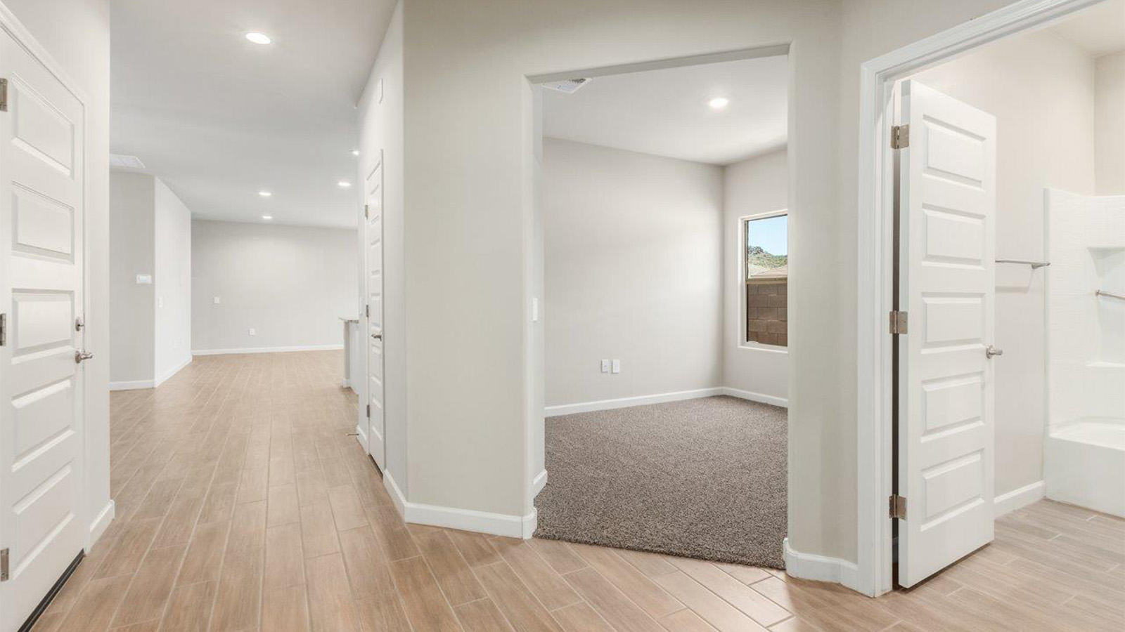 The Lakeway, situated within the beautiful Sycamore Vista community in Vail, Arizona, offers a perfect blend of functionality and comfort, ideal for both growing families and those who appreciate spacious living. With its 2,034 square feet of living space, this single-story new home features five bedrooms and three bathrooms, all meticulously designed to maximize space and convenience.  Entering The Lakeway, you’ll immediately notice the bright and airy atmosphere that flows through the open-concept floor plan. The heart of the home is the great room, seamlessly connected to the kitchen and dining area. The kitchen is equipped with quartz countertops, Shaker-style cabinetry, and a large island that serves as a focal point for both meal preparation and casual gatherings.  The primary bedroom is a true retreat, offering a spacious walk-in closet and an en-suite bathroom. The additional bedrooms are thoughtfully spaced to provide ample privacy for family members or guests, and the two secondary bathrooms are finished with modern fixtures and plenty of storage. This home offers a 2-3 car garage option for substantial space of vehicles and storage, accommodating the practical needs of busy households.  Standard features in The Lakeway at Sycamore Vista include energy-efficient elements like a tankless water heater, spray foam insulation, and LED lighting throughout. The home also comes with a Home is Connected® Smart Home package, which includes a smart thermostat, video doorbell, keyless entry, and more, ensuring modern conveniences are at your fingertips. The front yard is beautifully landscaped and includes an auto drip irrigation system, enhancing the curb appeal of this stunning home.  Nestled within Sycamore Vista, The Lakeway combines the tranquility of a rural setting with proximity to excellent schools, shopping, dining, and outdoor recreation, making it an exceptional place to call home.