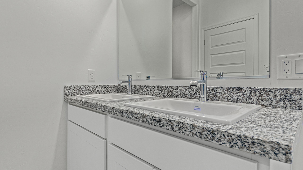 Step into The Baxter at Casas del Cerrito in Tucson, Arizona – a beautifully designed 1,423 sq. ft. single-story new home that perfectly blends modern convenience with the serene beauty of the surrounding desert landscape.  As you enter through the welcoming front porch, you’re greeted by a thoughtfully planned entryway that leads into the heart of the home – a spacious and open-concept great room. This central living area flows seamlessly into the dining space, creating an ideal environment for both entertaining and everyday family life.  The gourmet kitchen, situated adjacent to the dining room, features elegant granite countertops, a large island with a breakfast bar, modern appliances, and a walk-in pantry, providing ample storage and a perfect space for culinary creativity.  The master suite, located at the rear of the home for added privacy, offers a generous walk-in closet and a luxurious en-suite bathroom with dual vanities and a walk-in shower. Large windows allow plenty of natural light to fill the space, creating a tranquil retreat.  Two additional bedrooms are positioned near the front of the home, each with easy access to a full bathroom. These rooms are perfect for family members, guests, or a home office, offering flexibility to suit your lifestyle.  For added convenience, the home includes a utility room and a two-car garage, ensuring that daily routines are efficient and organized.  Step outside to the covered patio, where you can relax and enjoy the stunning mountain views and Tucson’s beautiful weather year-round. Whether you’re hosting a weekend barbecue or enjoying a quiet evening outdoors, this space extends your living area into the peaceful surroundings of Casas del Cerrito.  Designed with energy efficiency in mind, The Baxter at Casas del Cerrito is a DOE Zero Energy Ready Home, ensuring long-term savings and a sustainable living environment.