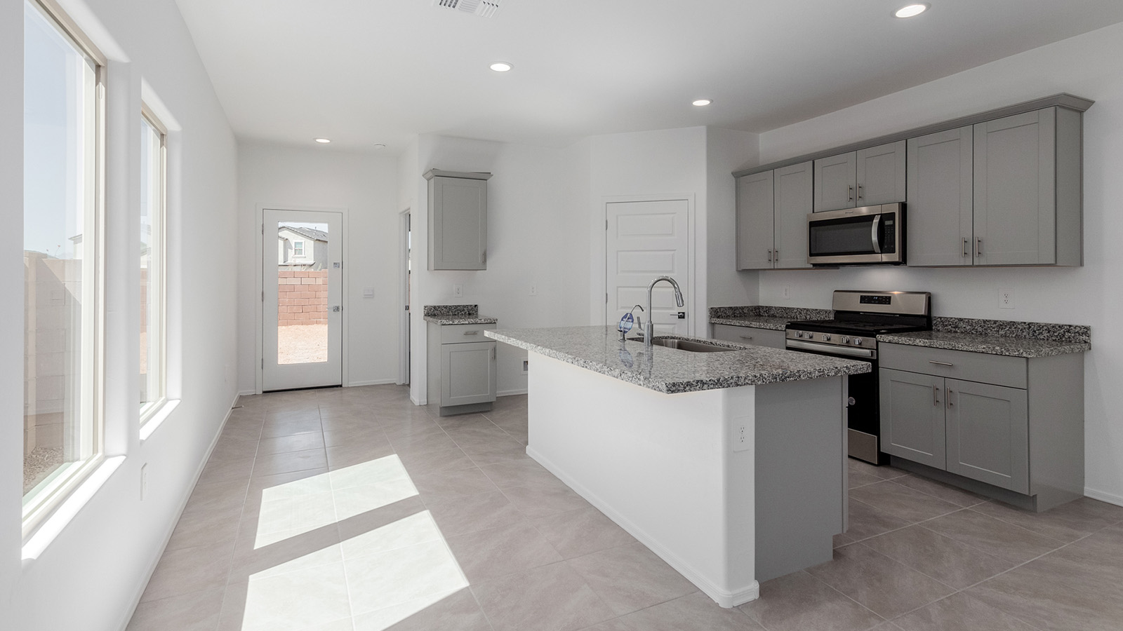 Discover The Diana, a well-planned single-story new home in the vibrant Senita Crossing community. Spanning 1,558 square feet, this residence offers three bedrooms and two bathrooms, all within a layout that emphasizes comfort and ease of living.  As you enter through the front porch, you're greeted by a welcoming foyer that opens into the sprawling great room. This space, designed to be the heart of the home, flows effortlessly into the dining area and kitchen, making it ideal for both everyday living and entertaining. The kitchen is outfitted with a large island, granite countertops, and stylish Shaker-style cabinetry, combining practicality with a touch of sophistication. A generous pantry ensures that storage is never an issue, and stainless steel appliances, including a gas range, microwave, and dishwasher, are all standard, enhancing your cooking experience.  The primary bedroom is thoughtfully located at the rear of the home, providing a private retreat complete with a spacious walk-in closet and an en-suite bathroom featuring dual vanities. The additional two bedrooms are positioned at the opposite end of the home, each with easy access to the second bathroom, making this layout perfect for families or guests.  Outdoor living is a key feature of The Diana, with a covered patio that extends your living space to the outside. Whether you’re enjoying a quiet morning coffee or hosting an evening gathering, this space is perfect for taking advantage of Tucson’s beautiful weather.  Senita Crossing is a community that blends convenience with comfort. Located on Tucson’s southeast side, residents enjoy easy access to I-10, Davis-Monthan Air Force Base, and major employers like Raytheon, making it an ideal location for both families and professionals. Inside The Diana, modern conveniences like 12”x12” ceramic tile flooring, granite countertops, and stainless steel appliances are standard, ensuring that your home is as functional as it is beautiful.  Energy efficiency is a priority in The Diana, with features like a tankless water heater, LED lighting, and advanced spray foam insulation, all contributing to lower energy costs and a smaller carbon footprint. The home is also equipped with D.R. Horton’s Home is Connected® Smart Home package, which includes a smart thermostat, video doorbell, keyless entry, and more, providing both convenience and peace of mind.  Living in Senita Crossing means access to top-rated schools in the Sunnyside Unified School District, as well as proximity to outdoor destinations like Sabino Canyon and cultural attractions like the Tucson Botanical Gardens. The community offers amenities such as a park, playground, and maintained walking and biking trails, making it a perfect place for families to thrive.  The Diana at Senita Crossing is more than just a home; it’s a place where comfort, convenience, and modern living come together to create the perfect environment for you and your family.