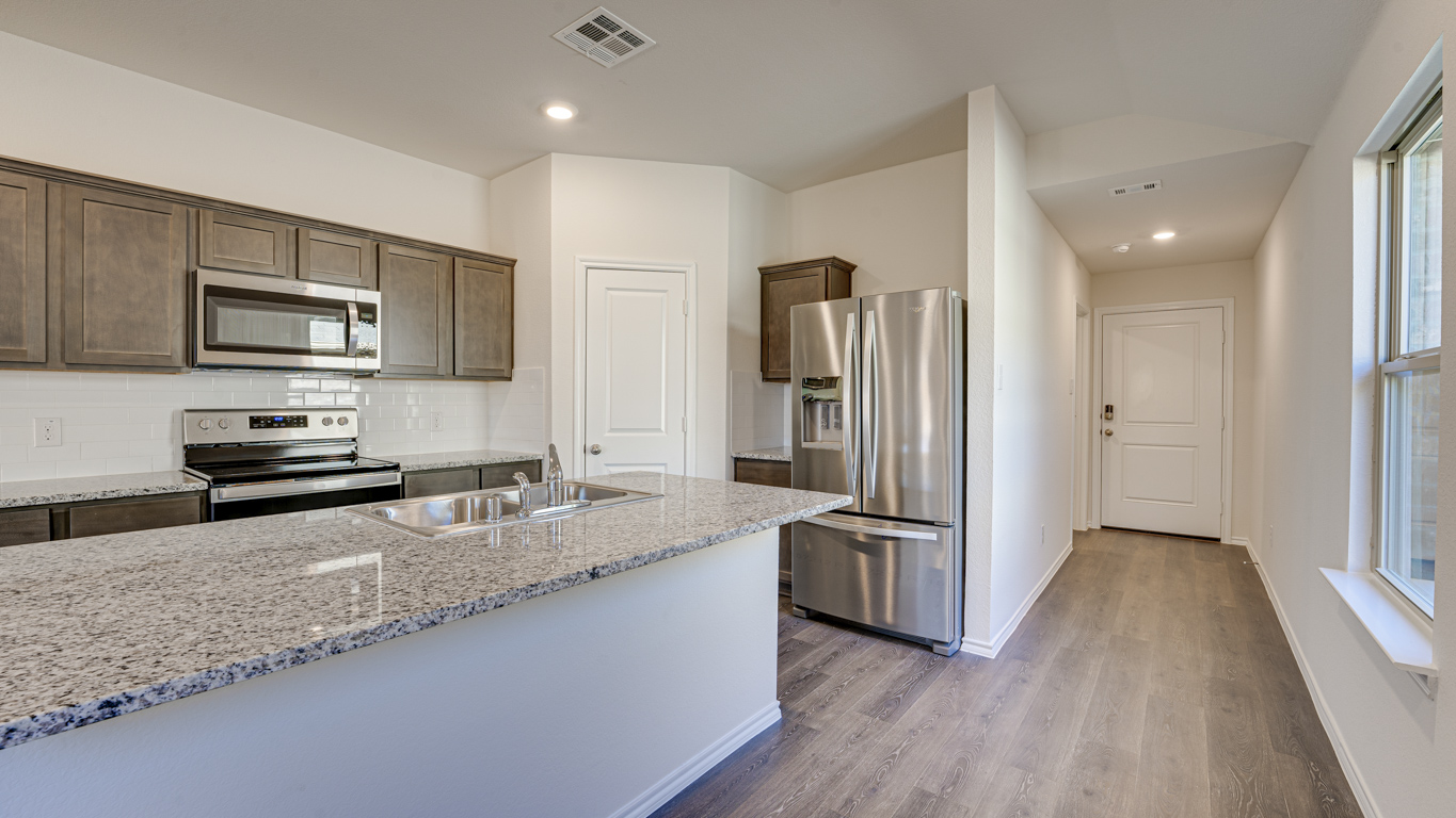 Welcome to The Amber at Blackhawk in Tucson, Arizona – a charming 1,331 sq. ft. single-story new home designed to offer both comfort and style in a prime location.  As you step through the front porch, you're greeted by an inviting entryway that opens up into a beautifully designed living space. The great room serves as the heart of the home, providing a spacious area for relaxing, entertaining, or enjoying family time. This open-concept design flows seamlessly into the dining area and kitchen.  The kitchen is a true centerpiece, featuring elegant quartz countertops, modern appliances, a pantry for ample storage, and a convenient breakfast bar. Whether you’re preparing a quick meal or hosting a dinner party, this kitchen is equipped to meet your needs with both style and functionality.  Just off the great room, you’ll find the primary bedroom – a private retreat designed for relaxation. The primary bedroom is generously sized and includes a walk-in closet and an en-suite bathroom, offering both luxury and convenience.   The Amber also includes two additional bedrooms, well-positioned to share a full bathroom. These rooms are ideal for family members, guests, or even a home office.  For added convenience, the home includes a utility room located near the bedrooms, and a two-car garage that offers both storage and functionality. Step outside to the covered patio, where you can unwind and enjoy Tucson’s beautiful weather year-round. Whether you’re sipping your morning coffee or hosting a weekend barbecue, this outdoor space extends your living area into the serene surroundings of Blackhawk.  Designed with energy efficiency in mind, The Amber at Blackhawk is a DOE Zero Energy Ready Home, ensuring long-term savings and a sustainable living environment.  *Images shown are for reference only. They depict the Amber model and may not represent the actual home.