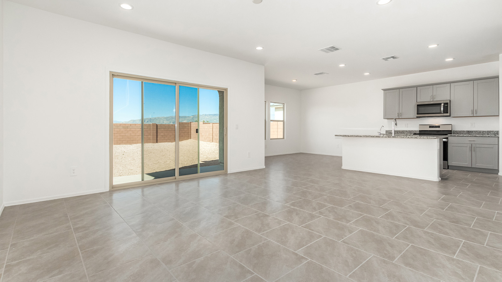 Introducing The Grace at Blackhawk in Tucson, Arizona – a spacious 1,963 sq. ft. two-story new home designed to accommodate modern living with style and functionality.  As you step through the welcoming front porch, you’re greeted by an open and inviting entryway that leads directly into the heart of the home. The main level features a spacious great room that flows seamlessly into the dining area and the modern kitchen, creating a perfect space for entertaining and family gatherings. The kitchen is equipped with elegant granite countertops, a large island with a breakfast bar, modern appliances, and a pantry that offers plenty of storage, making it as functional as it is stylish.  The main floor also includes a convenient powder room for guests, and direct access to the two-car garage, enhancing the home’s functionality and ease of living.  Heading upstairs, you'll discover the family’s private quarters. The master suite is a serene retreat, featuring a generously sized bedroom, a large walk-in closet, and an en-suite bathroom complete with dual vanities and a walk-in shower. The upper level also includes three additional bedrooms, a full bathroom, and a utility room conveniently located for easy access to all bedrooms. Additionally, a versatile loft area serves as a flexible space that can be used as a game room, home office, or even a second living area.  Back downstairs, step outside from the great room to the covered patio, where you can enjoy Tucson’s beautiful weather year-round. Whether you’re hosting an outdoor gathering or simply relaxing after a long day, this space extends your living area and enhances the home’s inviting ambiance.  Designed with energy efficiency in mind, The Grace at Blackhawk is a DOE Zero Energy Ready Home, ensuring sustainability, comfort, and long-term savings.