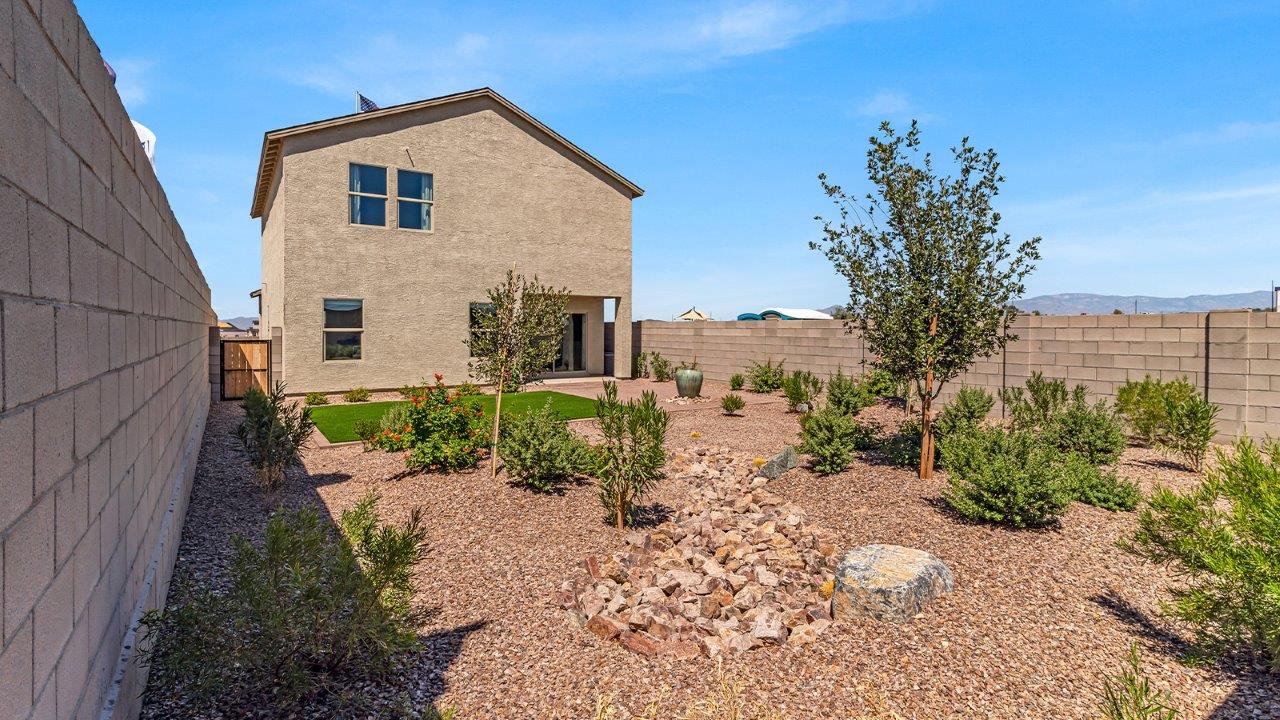 Introducing The Kate at Blackhawk in Tucson, Arizona – a spacious 2,264 sq. ft. two-story new home designed to offer both comfort and modern living in a prime location.  As you step through the inviting front porch, you’re welcomed into a thoughtfully designed entryway that leads directly into the heart of the home. The main floor boasts a generous great room that seamlessly connects to the dining area and kitchen, creating an ideal space for entertaining and everyday living. The kitchen is equipped with sleek granite countertops, a large island with a breakfast bar, modern appliances, and a pantry that provides ample storage, ensuring that the kitchen is both functional and stylish.  The main level also features a convenient powder room, perfect for guests, and direct access to the two-car garage, enhancing the home’s practicality.  Heading upstairs, you’ll discover the family’s private quarters. The master suite offers a serene retreat, complete with a spacious bedroom, a large walk-in closet, and an en-suite bathroom featuring dual vanities and a walk-in shower. The upper level also includes three additional bedrooms, a full bathroom, and a utility room centrally located for easy access. Additionally, a versatile loft area provides extra space that can be tailored to fit your lifestyle, whether as a game room, home office, or a second living area.  Step outside from the great room to the covered patio, where you can enjoy Tucson’s beautiful weather year-round. Whether you’re hosting an outdoor gathering or simply relaxing after a long day, this space extends your living area and enhances the home’s inviting ambiance.  Designed with energy efficiency in mind, The Kate at Blackhawk is a DOE Zero Energy Ready Home, combining sustainability, comfort, and long-term savings.