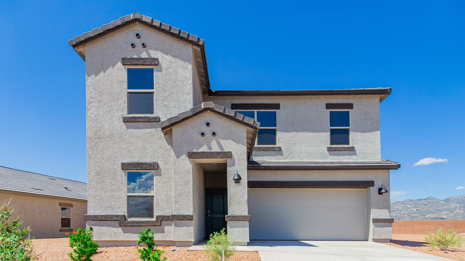 Introducing The River plan at The Oasis at Rocking K, a standout two-story new home that epitomizes spacious living and modern amenities in the scenic backdrop of Vail, Arizona. Nestled within this master-planned community, The River offers an impressive 2,396 square feet of living space, making it the largest floorplan available at The Oasis. This home is intentionally designed to accommodate the needs of growing families, with five bedrooms and three bathrooms, ensuring plenty of space for everyone.  The exterior of The River plan exudes charm and character, with its Spanish lace stucco finish and tile roof that blends seamlessly into the picturesque surroundings. The home’s front yard is meticulously landscaped with auto drip irrigation, providing a welcoming entrance to this beautiful residence.  Upon entering The River, you'll be greeted by a bright and inviting great room that flows effortlessly into the dining room and kitchen, creating a harmonious space perfect for entertaining or family gatherings. The kitchen is a chef’s day dream, featuring quartz countertops, 42” shaker-style cabinets, and stainless steel appliances, all designed to inspire culinary creativity. The main floor also includes the luxurious owner’s suite, which serves as a private sanctuary. This suite features a spacious walk-in closet and an en-suite bathroom with dual vanities, a walk-in shower, and a soaking tub, providing the perfect retreat at the end of the day. Additionally, a second bedroom on the main floor offers flexibility, ideal for guests or a home office.  As you ascend to the second story, you'll find three additional bedrooms, all with easy access to a full bathroom. A generous loft area on the second floor offers additional living space, ideal for a media room, play area, or home gym.  The River plan is not just about style and space; it’s also about modern convenience and energy efficiency. The home is equipped with D.R. Horton’s Home is Connected® Smart Home package, which includes a smart thermostat, video doorbell, keyless entry, Wi-Fi-enabled garage door opener, and Deako light switches, ensuring that your home is as functional as it is beautiful. Additionally, the home meets the DOE Zero Energy Ready Home standards, featuring energy-efficient elements such as spray foam insulation, a tankless water heater, LED lighting throughout and more.  Living at The Oasis at Rocking K means more than just owning a home; it means being part of a vibrant community. With access to amenities like ramadas, picnic areas, walking paths, and recreational fields, plus the greater Rocking K master-planned neighborhood’s splashpad, event lawn, playground, and events, there’s always something to do. Residents also enjoy the convenience of nearby schools, shopping, dining, and outdoor recreational opportunities, making The Oasis at Rocking K the perfect place to call home.  The River plan at The Oasis at Rocking K is where space, style, and smart living converge, offering a home designed for the way you live today.