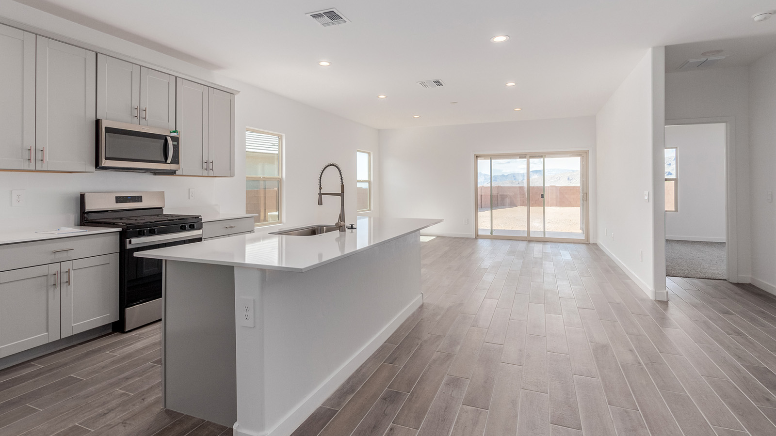 Introducing The River plan at The Oasis at Rocking K, a standout two-story new home that epitomizes spacious living and modern amenities in the scenic backdrop of Vail, Arizona. Nestled within this master-planned community, The River offers an impressive 2,396 square feet of living space, making it the largest floorplan available at The Oasis. This home is intentionally designed to accommodate the needs of growing families, with five bedrooms and three bathrooms, ensuring plenty of space for everyone.  The exterior of The River plan exudes charm and character, with its Spanish lace stucco finish and tile roof that blends seamlessly into the picturesque surroundings. The home’s front yard is meticulously landscaped with auto drip irrigation, providing a welcoming entrance to this beautiful residence.  Upon entering The River, you'll be greeted by a bright and inviting great room that flows effortlessly into the dining room and kitchen, creating a harmonious space perfect for entertaining or family gatherings. The kitchen is a chef’s day dream, featuring quartz countertops, 42” shaker-style cabinets, and stainless steel appliances, all designed to inspire culinary creativity. The main floor also includes the luxurious owner’s suite, which serves as a private sanctuary. This suite features a spacious walk-in closet and an en-suite bathroom with dual vanities, a walk-in shower, and a soaking tub, providing the perfect retreat at the end of the day. Additionally, a second bedroom on the main floor offers flexibility, ideal for guests or a home office.  As you ascend to the second story, you'll find three additional bedrooms, all with easy access to a full bathroom. A generous loft area on the second floor offers additional living space, ideal for a media room, play area, or home gym.  The River plan is not just about style and space; it’s also about modern convenience and energy efficiency. The home is equipped with D.R. Horton’s Home is Connected® Smart Home package, which includes a smart thermostat, video doorbell, keyless entry, Wi-Fi-enabled garage door opener, and Deako light switches, ensuring that your home is as functional as it is beautiful. Additionally, the home meets the DOE Zero Energy Ready Home standards, featuring energy-efficient elements such as spray foam insulation, a tankless water heater, LED lighting throughout and more.  Living at The Oasis at Rocking K means more than just owning a home; it means being part of a vibrant community. With access to amenities like ramadas, picnic areas, walking paths, and recreational fields, plus the greater Rocking K master-planned neighborhood’s splashpad, event lawn, playground, and events, there’s always something to do. Residents also enjoy the convenience of nearby schools, shopping, dining, and outdoor recreational opportunities, making The Oasis at Rocking K the perfect place to call home.  The River plan at The Oasis at Rocking K is where space, style, and smart living converge, offering a home designed for the way you live today.