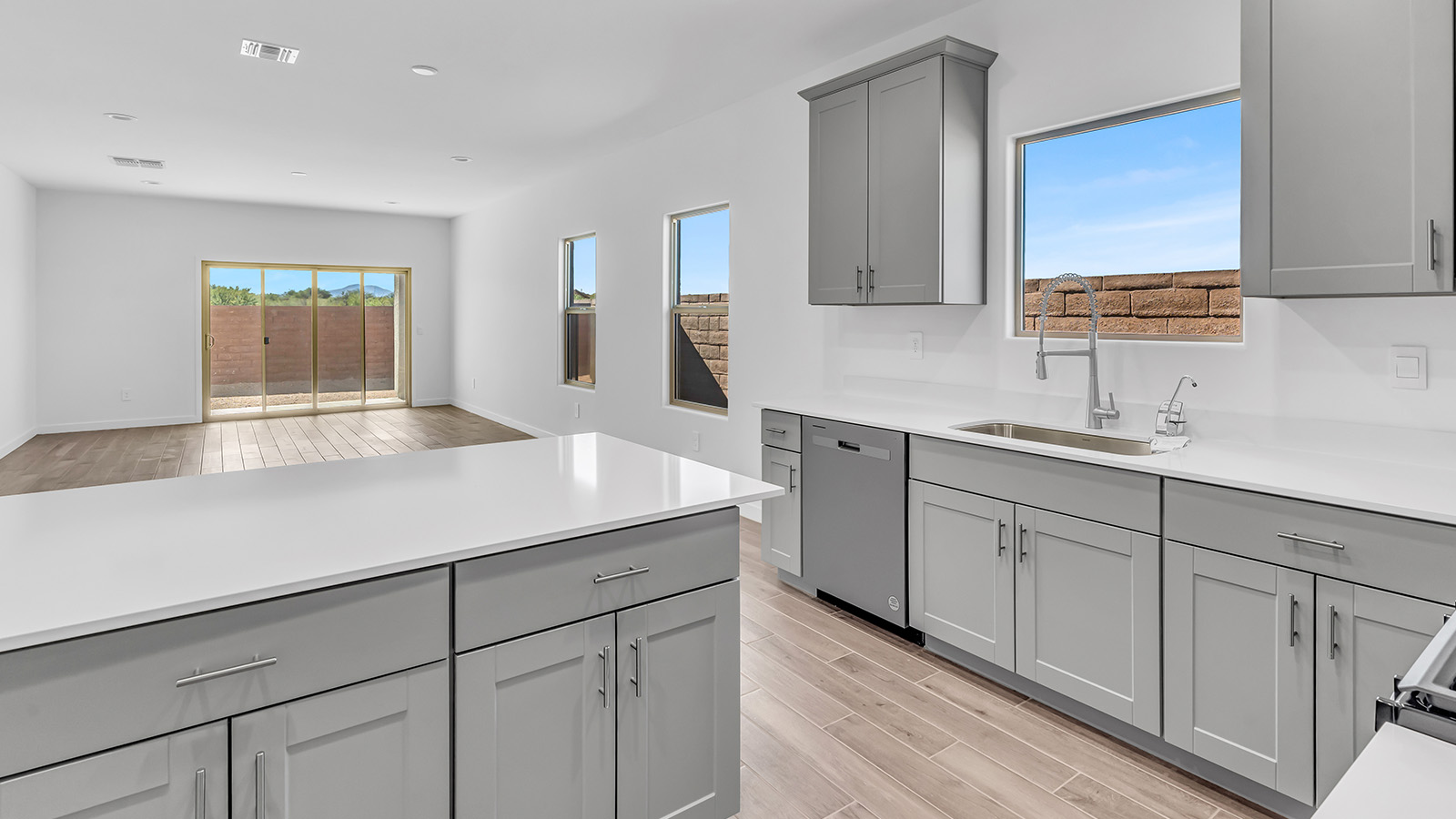 The Parker floor plan is one of the expansive new homes featured at The Oasis at Rocking K in Vail, Arizona. This vibrant community is nestled against the backdrop of the Rincon Mountains. The Parker stands out as a spacious single-story new home, offering 1,914 square feet of living space, making it the largest single-story floorplan available in this community.  The Parker is a reflection of elegance that defines The Oasis at Rocking K. The beautifully landscaped front yard, complete with an irrigation system, enhances the curb appeal, with a covered front porch.  Step into a well-planned layout that effortlessly balances functionality. The Parker features five bedrooms, including a private primary suite with a walk-in closet and en-suite bathroom. The additional bedrooms are thoughtfully situated to provide privacy and comfort, with easy access to two full bathrooms.  The heart of The Parker is the kitchen, which seamlessly connects to the dining room and great room. The kitchen is equipped with high-end finishes, including quartz countertops, shaker-style cabinets, and stainless-steel appliances. A generous pantry and plenty of cabinet space ensure that storage is never an issue.  The Parker includes a covered back patio, perfect for enjoying the tranquility of the surrounding landscape. Inside, the home features durable wood-look tile flooring in the main living areas, adding warmth and elegance to the space.  The Parker comes equipped with the Home is Connected® Smart Home package. This includes a smart thermostat, video doorbell, keyless entry, and more. Additionally, the home meets DOE Zero Energy Ready Home standards, with features like spray foam insulation and tankless water heaters, ensuring long-term savings and a reduced environmental footprint.  Living in The Oasis at Rocking K means enjoying a community rich in amenities. Whether you’re seeking a peaceful retreat or an active lifestyle, The Parker at The Oasis at Rocking K offers the perfect home base.