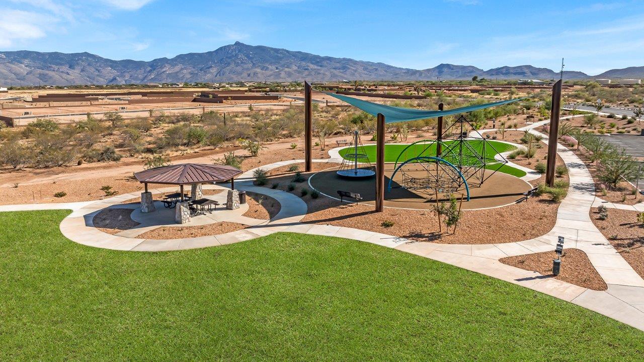 The Parker floor plan is one of the expansive new homes featured at The Oasis at Rocking K in Vail, Arizona. This vibrant community is nestled against the backdrop of the Rincon Mountains. The Parker stands out as a spacious single-story new home, offering 1,914 square feet of living space, making it the largest single-story floorplan available in this community.  The Parker is a reflection of elegance that defines The Oasis at Rocking K. The beautifully landscaped front yard, complete with an irrigation system, enhances the curb appeal, with a covered front porch.  Step into a well-planned layout that effortlessly balances functionality. The Parker features five bedrooms, including a private primary suite with a walk-in closet and en-suite bathroom. The additional bedrooms are thoughtfully situated to provide privacy and comfort, with easy access to two full bathrooms.  The heart of The Parker is the kitchen, which seamlessly connects to the dining room and great room. The kitchen is equipped with high-end finishes, including quartz countertops, shaker-style cabinets, and stainless-steel appliances. A generous pantry and plenty of cabinet space ensure that storage is never an issue.  The Parker includes a covered back patio, perfect for enjoying the tranquility of the surrounding landscape. Inside, the home features durable wood-look tile flooring in the main living areas, adding warmth and elegance to the space.  The Parker comes equipped with the Home is Connected® Smart Home package. This includes a smart thermostat, video doorbell, keyless entry, and more. Additionally, the home meets DOE Zero Energy Ready Home standards, with features like spray foam insulation and tankless water heaters, ensuring long-term savings and a reduced environmental footprint.  Living in The Oasis at Rocking K means enjoying a community rich in amenities. Whether you’re seeking a peaceful retreat or an active lifestyle, The Parker at The Oasis at Rocking K offers the perfect home base.