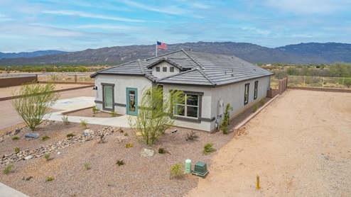 Welcome to The Oasis at Rocking K, a premier D.R. Horton new home community nestled in the picturesque landscapes of Vail, Arizona, where new homes blend seamlessly with the breathtaking surroundings of the Rincon Mountains. Experience the perfect balance of tranquility and modern convenience in this master-planned neighborhood, designed to offer a lifestyle that caters to families, nature enthusiasts, and anyone seeking a peaceful yet connected community. The Oasis at Rocking K features five beautifully designed one-story floor plans ranging from 1,400 to 1,900 square feet, each crafted with the high-quality features and finishes D.R. Horton is known for. Homes in Rocking K feature a Spanish lace stucco exterior, tile roofs, and meticulously landscaped front yards with auto drip irrigation. Inside, you’ll find luxurious quartz countertops in the kitchens and bathrooms, 42” shaker-style cabinets with modern cabinet pulls, and wood-look tile flooring throughout the main living areas. Homes also include covered front porches and back patios, perfect for enjoying Arizona’s stunning sunsets and clear night skies. Each home in The Oasis at Rocking K is equipped with D.R. Horton’s Home is Connected® Smart Home package, which includes a smart thermostat, video doorbell, keyless entry, Wi-Fi-enabled garage door opener, and Deako light switches. Additionally, these homes meet the stringent DOE Zero Energy Ready Home standards, making them not only comfortable and modern but also exceptionally energy-efficient. With features like spray foam insulation, tankless water heaters and LED lighting, these homes are designed to reduce your environmental footprint and provide long-term savings on energy costs. Living at Rocking K means being part of a vibrant, family-oriented community with a strong sense of connection among residents. The Oasis at Rocking K offers a variety of amenities, including ramadas, picnic tables, and grassy areas perfect for gatherings. Residents also have access to the greater Rocking K master-planned neighborhood amenities, such as a splashpad, large event lawn, walking paths, multipurpose fields, basketball and pickleball courts, and an innovative playground with a zip-line and jungle gym. The new K-8 school, set to open in 2025, is just one of the many features that make Rocking K ideal for families. Life at Rocking K is further enriched by a lively calendar of lifestyle events, thoughtfully organized by the Rocking K Homeowners Association. These events are a cornerstone of community life, fostering a strong sense of connection among residents. Whether you’re looking to enjoy a quiet evening star gazing in the park or engage in fun activities with neighbors, there’s always something happening. The quarterly lifestyle calendar is packed with regular and seasonal events, including movie nights in the park, sports and summer camps for kids, and wine tasting events for adults. Families can join hiking groups, participate in trivia nights, or enjoy the various holiday celebrations. The community comes alive during the holidays with loads of themed events, arts and crafts fairs, and car shows. Rocking K’s commitment to providing a dynamic and engaging environment ensures that there’s always an opportunity to make memories and build lasting friendships right in your neighborhood. Residents of Rocking K benefit from easy access to I-10, making commutes to Tucson and surrounding areas a breeze. The community is close to major employers such as Davis-Monthan Air Force Base, Raytheon, and the University of Arizona, as well as top-notch healthcare facilities like TMC Rincon and Northwest Hospital East. The nearby Houghton Town Center and Houghton Rd. business corridor offer convenient shopping, dining, and services. For outdoor enthusiasts, Rocking K is surrounded by natural beauty and recreational opportunities. Explore the hiking and biking trails at Colossal Cave Mountain Park, Saguaro National Park East, and the Arizona Trail. Enjoy golfing at Del Lago Golf Course, or take a short drive to Sonoita for a day trip to Arizona’s Wine Country. Whether it’s hiking, camping, or simply taking in the stunning views, Rocking K is your gateway to the great outdoors. With 360-degree mountain views, calm and quiet evenings, and a location that’s close to everything you need, Rocking K is truly a community where you can thrive. Experience the best of Arizona living at The Oasis at Rocking K, where your new home awaits in a community that offers everything you need for a fulfilling lifestyle.