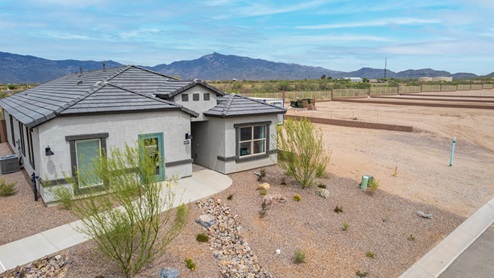 Welcome to The Oasis at Rocking K, a premier D.R. Horton new home community nestled in the picturesque landscapes of Vail, Arizona, where new homes blend seamlessly with the breathtaking surroundings of the Rincon Mountains. Experience the perfect balance of tranquility and modern convenience in this master-planned neighborhood, designed to offer a lifestyle that caters to families, nature enthusiasts, and anyone seeking a peaceful yet connected community. The Oasis at Rocking K features five beautifully designed one-story floor plans ranging from 1,400 to 1,900 square feet, each crafted with the high-quality features and finishes D.R. Horton is known for. Homes in Rocking K feature a Spanish lace stucco exterior, tile roofs, and meticulously landscaped front yards with auto drip irrigation. Inside, you’ll find luxurious quartz countertops in the kitchens and bathrooms, 42” shaker-style cabinets with modern cabinet pulls, and wood-look tile flooring throughout the main living areas. Homes also include covered front porches and back patios, perfect for enjoying Arizona’s stunning sunsets and clear night skies. Each home in The Oasis at Rocking K is equipped with D.R. Horton’s Home is Connected® Smart Home package, which includes a smart thermostat, video doorbell, keyless entry, Wi-Fi-enabled garage door opener, and Deako light switches. Additionally, these homes meet the stringent DOE Zero Energy Ready Home standards, making them not only comfortable and modern but also exceptionally energy-efficient. With features like spray foam insulation, tankless water heaters and LED lighting, these homes are designed to reduce your environmental footprint and provide long-term savings on energy costs. Living at Rocking K means being part of a vibrant, family-oriented community with a strong sense of connection among residents. The Oasis at Rocking K offers a variety of amenities, including ramadas, picnic tables, and grassy areas perfect for gatherings. Residents also have access to the greater Rocking K master-planned neighborhood amenities, such as a splashpad, large event lawn, walking paths, multipurpose fields, basketball and pickleball courts, and an innovative playground with a zip-line and jungle gym. The new K-8 school, set to open in 2025, is just one of the many features that make Rocking K ideal for families. Life at Rocking K is further enriched by a lively calendar of lifestyle events, thoughtfully organized by the Rocking K Homeowners Association. These events are a cornerstone of community life, fostering a strong sense of connection among residents. Whether you’re looking to enjoy a quiet evening star gazing in the park or engage in fun activities with neighbors, there’s always something happening. The quarterly lifestyle calendar is packed with regular and seasonal events, including movie nights in the park, sports and summer camps for kids, and wine tasting events for adults. Families can join hiking groups, participate in trivia nights, or enjoy the various holiday celebrations. The community comes alive during the holidays with loads of themed events, arts and crafts fairs, and car shows. Rocking K’s commitment to providing a dynamic and engaging environment ensures that there’s always an opportunity to make memories and build lasting friendships right in your neighborhood. Residents of Rocking K benefit from easy access to I-10, making commutes to Tucson and surrounding areas a breeze. The community is close to major employers such as Davis-Monthan Air Force Base, Raytheon, and the University of Arizona, as well as top-notch healthcare facilities like TMC Rincon and Northwest Hospital East. The nearby Houghton Town Center and Houghton Rd. business corridor offer convenient shopping, dining, and services. For outdoor enthusiasts, Rocking K is surrounded by natural beauty and recreational opportunities. Explore the hiking and biking trails at Colossal Cave Mountain Park, Saguaro National Park East, and the Arizona Trail. Enjoy golfing at Del Lago Golf Course, or take a short drive to Sonoita for a day trip to Arizona’s Wine Country. Whether it’s hiking, camping, or simply taking in the stunning views, Rocking K is your gateway to the great outdoors. With 360-degree mountain views, calm and quiet evenings, and a location that’s close to everything you need, Rocking K is truly a community where you can thrive. Experience the best of Arizona living at The Oasis at Rocking K, where your new home awaits in a community that offers everything you need for a fulfilling lifestyle.