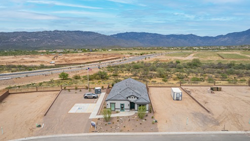 Welcome to The Oasis at Rocking K, a premier D.R. Horton new home community nestled in the picturesque landscapes of Vail, Arizona, where new homes blend seamlessly with the breathtaking surroundings of the Rincon Mountains. Experience the perfect balance of tranquility and modern convenience in this master-planned neighborhood, designed to offer a lifestyle that caters to families, nature enthusiasts, and anyone seeking a peaceful yet connected community. The Oasis at Rocking K features five beautifully designed one-story floor plans ranging from 1,400 to 1,900 square feet, each crafted with the high-quality features and finishes D.R. Horton is known for. Homes in Rocking K feature a Spanish lace stucco exterior, tile roofs, and meticulously landscaped front yards with auto drip irrigation. Inside, you’ll find luxurious quartz countertops in the kitchens and bathrooms, 42” shaker-style cabinets with modern cabinet pulls, and wood-look tile flooring throughout the main living areas. Homes also include covered front porches and back patios, perfect for enjoying Arizona’s stunning sunsets and clear night skies. Each home in The Oasis at Rocking K is equipped with D.R. Horton’s Home is Connected® Smart Home package, which includes a smart thermostat, video doorbell, keyless entry, Wi-Fi-enabled garage door opener, and Deako light switches. Additionally, these homes meet the stringent DOE Zero Energy Ready Home standards, making them not only comfortable and modern but also exceptionally energy-efficient. With features like spray foam insulation, tankless water heaters and LED lighting, these homes are designed to reduce your environmental footprint and provide long-term savings on energy costs. Living at Rocking K means being part of a vibrant, family-oriented community with a strong sense of connection among residents. The Oasis at Rocking K offers a variety of amenities, including ramadas, picnic tables, and grassy areas perfect for gatherings. Residents also have access to the greater Rocking K master-planned neighborhood amenities, such as a splashpad, large event lawn, walking paths, multipurpose fields, basketball and pickleball courts, and an innovative playground with a zip-line and jungle gym. The new K-8 school, set to open in 2025, is just one of the many features that make Rocking K ideal for families. Life at Rocking K is further enriched by a lively calendar of lifestyle events, thoughtfully organized by the Rocking K Homeowners Association. These events are a cornerstone of community life, fostering a strong sense of connection among residents. Whether you’re looking to enjoy a quiet evening star gazing in the park or engage in fun activities with neighbors, there’s always something happening. The quarterly lifestyle calendar is packed with regular and seasonal events, including movie nights in the park, sports and summer camps for kids, and wine tasting events for adults. Families can join hiking groups, participate in trivia nights, or enjoy the various holiday celebrations. The community comes alive during the holidays with loads of themed events, arts and crafts fairs, and car shows. Rocking K’s commitment to providing a dynamic and engaging environment ensures that there’s always an opportunity to make memories and build lasting friendships right in your neighborhood. Residents of Rocking K benefit from easy access to I-10, making commutes to Tucson and surrounding areas a breeze. The community is close to major employers such as Davis-Monthan Air Force Base, Raytheon, and the University of Arizona, as well as top-notch healthcare facilities like TMC Rincon and Northwest Hospital East. The nearby Houghton Town Center and Houghton Rd. business corridor offer convenient shopping, dining, and services. For outdoor enthusiasts, Rocking K is surrounded by natural beauty and recreational opportunities. Explore the hiking and biking trails at Colossal Cave Mountain Park, Saguaro National Park East, and the Arizona Trail. Enjoy golfing at Del Lago Golf Course, or take a short drive to Sonoita for a day trip to Arizona’s Wine Country. Whether it’s hiking, camping, or simply taking in the stunning views, Rocking K is your gateway to the great outdoors. With 360-degree mountain views, calm and quiet evenings, and a location that’s close to everything you need, Rocking K is truly a community where you can thrive. Experience the best of Arizona living at The Oasis at Rocking K, where your new home awaits in a community that offers everything you need for a fulfilling lifestyle.