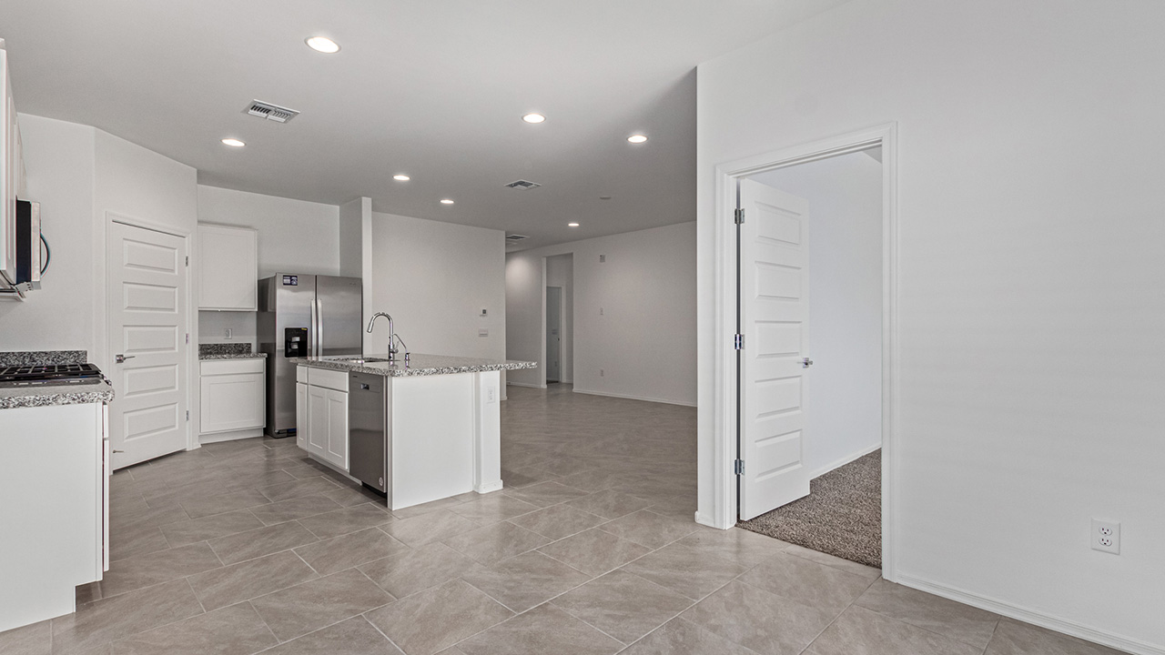 Explore The Baxter at The Oasis at Rocking K in Vail, Arizona, a meticulously designed single-story new home floorplan offering 1,423 square feet of beautifully appointed living space.  As you step inside, you'll immediately appreciate the open and inviting layout that seamlessly connects the great room, dining area, and kitchen. The heart of the home, the kitchen, is equipped with sleek stainless-steel appliances, including a built-in microwave and gas range. The central island with a breakfast bar serves as a gathering spot for casual meals and entertaining.  The adjacent dining room flows effortlessly into a covered patio, perfect for extending your living space outdoors. The great room, with its large windows, allows natural light to flood the space, creating a warm and welcoming atmosphere.  The primary suite is a private hideaway, featuring a spacious walk-in closet and an en-suite bathroom. Two additional bedrooms are located near the front of the home, offering ample space and privacy for family members or guests. These rooms share a well-appointed full bathroom.  Additional standard features of The Baxter include energy-efficient dual-pane windows, a tankless water heater, and smart home technology that allows you to control the thermostat, lighting, and security system from your smartphone. The home also comes with a fully landscaped front yard with automatic drip irrigation, ensuring your home looks beautiful with minimal effort.  The two-car garage, utility room with washer/dryer hookups, and abundant storage throughout the home make the Baxter not only stylish but incredibly functional, catering to the needs of modern living.  The Baxter at The Oasis at Rocking K is where thoughtful design meets convenience, making it the perfect home for those seeking a blend of comfort, style, and functionality.