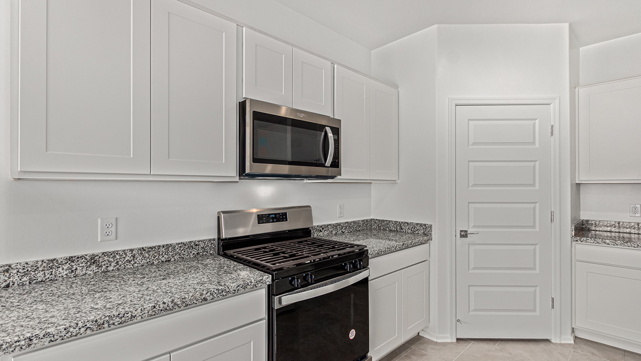 Explore The Baxter at The Oasis at Rocking K in Vail, Arizona, a meticulously designed single-story new home floorplan offering 1,423 square feet of beautifully appointed living space.  As you step inside, you'll immediately appreciate the open and inviting layout that seamlessly connects the great room, dining area, and kitchen. The heart of the home, the kitchen, is equipped with sleek stainless-steel appliances, including a built-in microwave and gas range. The central island with a breakfast bar serves as a gathering spot for casual meals and entertaining.  The adjacent dining room flows effortlessly into a covered patio, perfect for extending your living space outdoors. The great room, with its large windows, allows natural light to flood the space, creating a warm and welcoming atmosphere.  The primary suite is a private hideaway, featuring a spacious walk-in closet and an en-suite bathroom. Two additional bedrooms are located near the front of the home, offering ample space and privacy for family members or guests. These rooms share a well-appointed full bathroom.  Additional standard features of The Baxter include energy-efficient dual-pane windows, a tankless water heater, and smart home technology that allows you to control the thermostat, lighting, and security system from your smartphone. The home also comes with a fully landscaped front yard with automatic drip irrigation, ensuring your home looks beautiful with minimal effort.  The two-car garage, utility room with washer/dryer hookups, and abundant storage throughout the home make the Baxter not only stylish but incredibly functional, catering to the needs of modern living.  The Baxter at The Oasis at Rocking K is where thoughtful design meets convenience, making it the perfect home for those seeking a blend of comfort, style, and functionality.