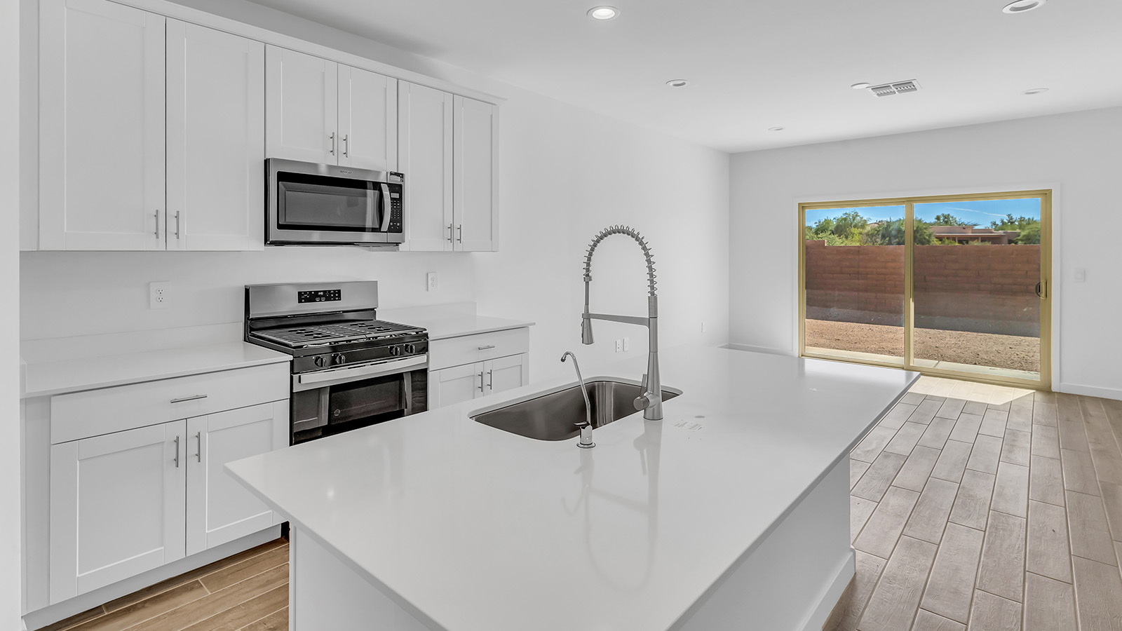 Discover The Harris, a beautifully designed new home at The Oasis at Rocking K, located in the serene surroundings of Vail, Arizona.  This charming one-story new home offers a seamless blend of style, functionality, and comfort, perfect for families and individuals alike. The Harris spans 1,856 square feet and includes four spacious bedrooms, two-and-a-half bathrooms, and a two-car garage, all meticulously crafted to meet the needs of modern living.  The exterior of The Harris offers three elevation options, each featuring D.R. Horton’s signature Spanish lace stucco, tile roofs, and professionally landscaped front yards with auto drip irrigation, adding to the home’s curb appeal. Inside, you’re greeted by an inviting foyer that leads to an open-concept living area, where the great room flows effortlessly into the dining area and a modern kitchen.  The kitchen is a chef's dream, equipped with top-of-the-line stainless steel appliances, quartz countertops, a large center island, and 42” shaker-style cabinets with stylish cabinet pulls. Adjacent to the kitchen, the dining area is perfect for family meals or entertaining guests. The great room, with its ample natural light and direct access to the covered patio, provides a perfect space for relaxation and gatherings.  The primary bedroom is a private sanctuary located at the back of the home, offering tranquility and easy access to the backyard. It features a walk-in closet and a luxurious en-suite bathroom with dual sinks and a large walk-in shower. The additional three bedrooms are generously sized, with two sharing a well-appointed full bathroom. A powder room, strategically placed near the living areas, adds convenience for guests.  Living at The Oasis at Rocking K means enjoying a variety of amenities, including ramadas, picnic areas, and access to the greater Rocking K master-planned community’s parks, walking trails, recreational facilities and events. Each home in this community also comes equipped with D.R. Horton’s Home is Connected® Smart Home package, offering the latest in modern living with features like a smart thermostat, video doorbell, and more.  Whether you’re looking for a home that offers space, style, or a sense of community, The Harris at The Oasis at Rocking K provides it all in a location that’s close to everything you need in Vail, Arizona.