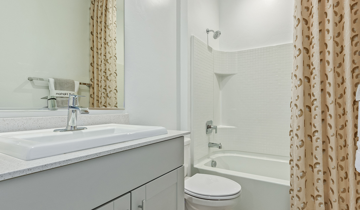 Step into The Kingston at Hanson Ridge in Vail Arizona – a perfect blend of comfort, modern living, and energy efficiency. This thoughtfully crafted single-story home spans 2,053 square feet and has four bedrooms and two bathrooms. This newly designed model offers harmony of comfort and desert elegance.  The open-concept design features a spacious great room that effortlessly connects with the kitchen and dining area, creating an inviting central hub for everyday living and entertaining. The kitchen is equipped with contemporary appliances and a pantry, offering ample storage and convenience for meal preparation and large center island. The primary bedroom, located at the rear of the home, provides a peaceful retreat with a private ensuite bathroom and a generous walk-in closet. The additional three bedrooms are positioned at the front of the house, offering versatility for use as guest rooms, a home office, or children’s bedrooms. Step outside to the covered patio, a perfect spot to enjoy the beautiful Arizona weather, whether for morning coffee or evening relaxation.  Built with energy efficiency as a priority, The Kingston includes smart home technology, which not only simplifies daily living but also helps reduce utility costs. A two-car garage provides ample parking and additional storage space, enhancing the home’s functionality. The Kingston at Hanson Ridge meets DOE Zero Energy Ready Home standards, ensuring sustainability and long-term savings.  Living at Hanson Ridge means more than just having a beautiful home. The community offers a peaceful lifestyle with incredible desert landscapes, mountain views, and easy access to I-10 for convenient commutes to Tucson and surrounding areas. Experience the charm and comfort of The Kingston at Hanson Ridge, where modern convenience meets the beauty of Arizona’s desert landscape.  *Images shown are for reference only. They depict the sales model home and may not represent the actual home.