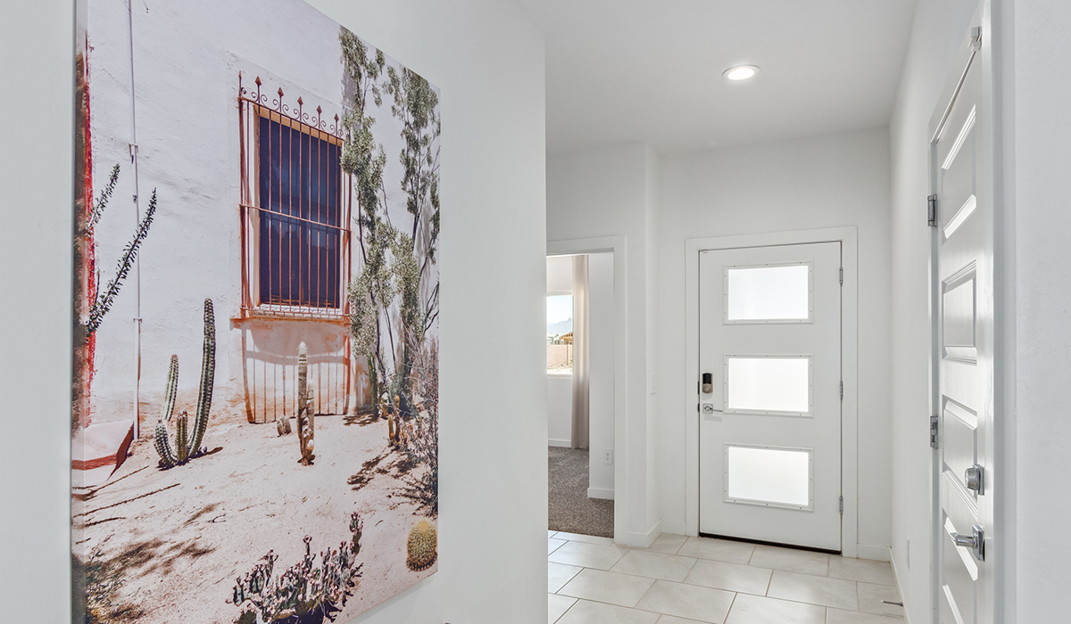 Step into The Kingston at Barnett Village, Marana, Arizona – a perfect blend of comfort, modern living, and energy efficiency. This thoughtfully crafted one-story home spans 2,068 square feet and offers four bedrooms and two bathrooms, ideal for families of all sizes.  The open-concept design features a spacious great room that effortlessly connects with the kitchen and dining area, creating an inviting central hub for everyday living and entertaining. The kitchen is equipped with contemporary appliances and a pantry, offering ample storage and convenience for meal preparation.  The primary bedroom, located at the rear of the home, provides a peaceful retreat with a private ensuite bathroom and a generous walk-in closet. The additional three bedrooms are positioned at the front of the house, offering versatility for use as guest rooms, a home office, or children’s bedrooms. Step outside to the covered patio, a perfect spot to enjoy the beautiful Arizona weather, whether for morning coffee or evening relaxation.  The Kingston also boasts a covered patio, perfect for enjoying Arizona’s beautiful desert evenings. Whether it’s morning coffee or evening relaxation, this outdoor space extends your living area into the serene landscape of Barnett Village.  Built with energy efficiency as a priority, the Kingston includes smart home technology, which not only simplifies daily living but also helps reduce utility costs. A two-car garage provides ample parking and additional storage space, enhancing the home’s functionality.