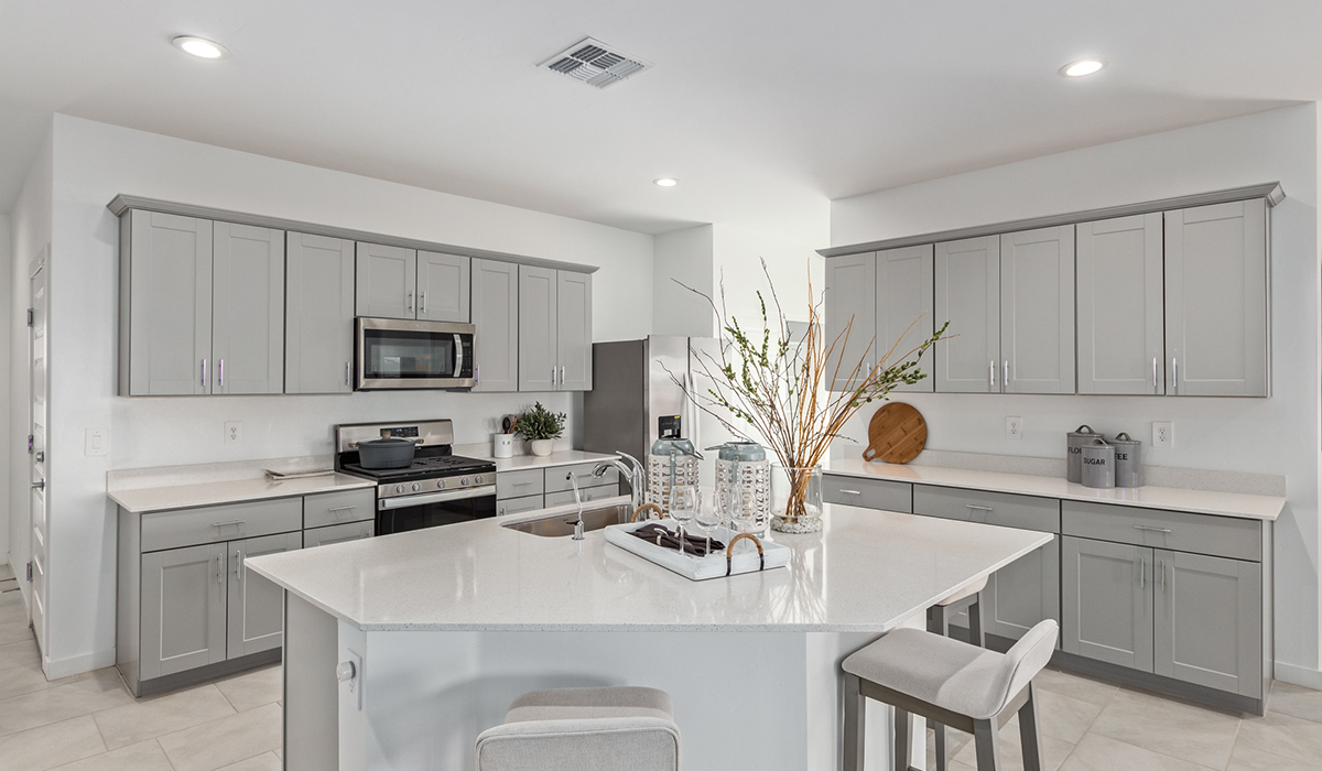 Step into The Kingston at Barnett Village, Marana, Arizona – a perfect blend of comfort, modern living, and energy efficiency. This thoughtfully crafted one-story home spans 2,068 square feet and offers four bedrooms and two bathrooms, ideal for families of all sizes.  The open-concept design features a spacious great room that effortlessly connects with the kitchen and dining area, creating an inviting central hub for everyday living and entertaining. The kitchen is equipped with contemporary appliances and a pantry, offering ample storage and convenience for meal preparation.  The primary bedroom, located at the rear of the home, provides a peaceful retreat with a private ensuite bathroom and a generous walk-in closet. The additional three bedrooms are positioned at the front of the house, offering versatility for use as guest rooms, a home office, or children’s bedrooms. Step outside to the covered patio, a perfect spot to enjoy the beautiful Arizona weather, whether for morning coffee or evening relaxation.  The Kingston also boasts a covered patio, perfect for enjoying Arizona’s beautiful desert evenings. Whether it’s morning coffee or evening relaxation, this outdoor space extends your living area into the serene landscape of Barnett Village.  Built with energy efficiency as a priority, the Kingston includes smart home technology, which not only simplifies daily living but also helps reduce utility costs. A two-car garage provides ample parking and additional storage space, enhancing the home’s functionality.