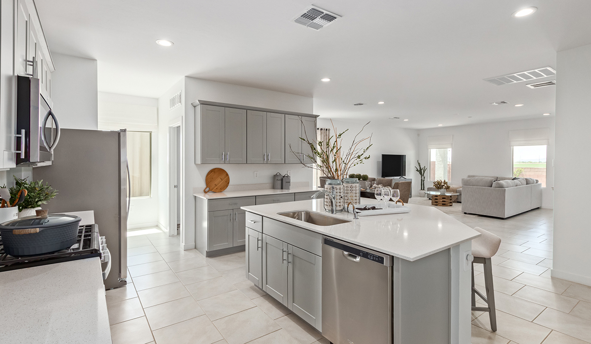 Step into The Kingston at Barnett Village, Marana, Arizona – a perfect blend of comfort, modern living, and energy efficiency. This thoughtfully crafted one-story home spans 2,068 square feet and offers four bedrooms and two bathrooms, ideal for families of all sizes.  The open-concept design features a spacious great room that effortlessly connects with the kitchen and dining area, creating an inviting central hub for everyday living and entertaining. The kitchen is equipped with contemporary appliances and a pantry, offering ample storage and convenience for meal preparation.  The primary bedroom, located at the rear of the home, provides a peaceful retreat with a private ensuite bathroom and a generous walk-in closet. The additional three bedrooms are positioned at the front of the house, offering versatility for use as guest rooms, a home office, or children’s bedrooms. Step outside to the covered patio, a perfect spot to enjoy the beautiful Arizona weather, whether for morning coffee or evening relaxation.  The Kingston also boasts a covered patio, perfect for enjoying Arizona’s beautiful desert evenings. Whether it’s morning coffee or evening relaxation, this outdoor space extends your living area into the serene landscape of Barnett Village.  Built with energy efficiency as a priority, the Kingston includes smart home technology, which not only simplifies daily living but also helps reduce utility costs. A two-car garage provides ample parking and additional storage space, enhancing the home’s functionality.