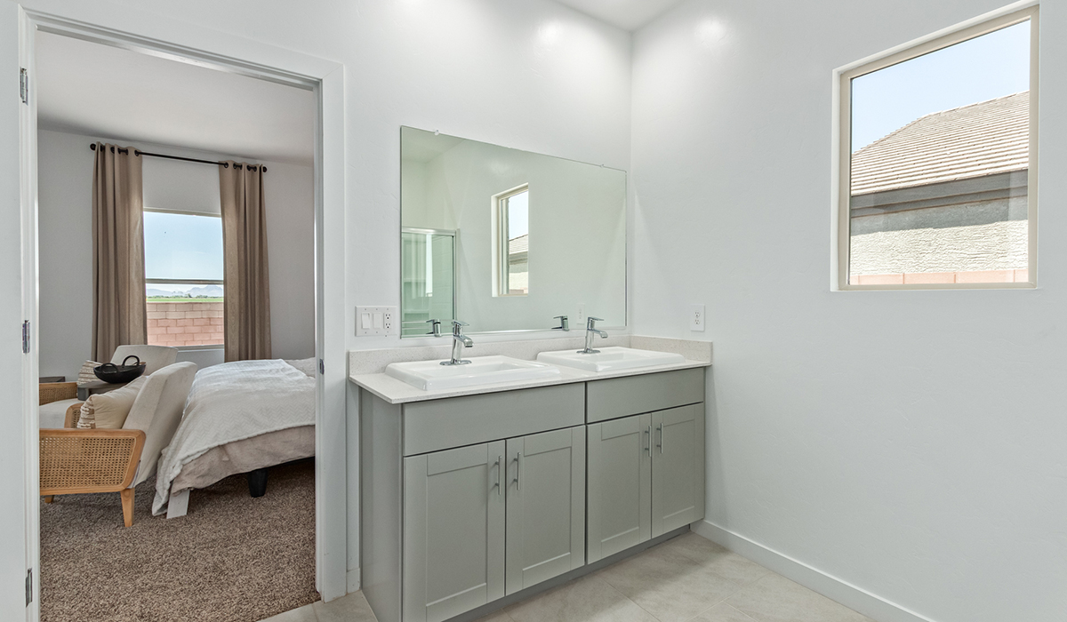 Step into The Kingston at Barnett Village, Marana, Arizona – a perfect blend of comfort, modern living, and energy efficiency. This thoughtfully crafted one-story home spans 2,068 square feet and offers four bedrooms and two bathrooms, ideal for families of all sizes.  The open-concept design features a spacious great room that effortlessly connects with the kitchen and dining area, creating an inviting central hub for everyday living and entertaining. The kitchen is equipped with contemporary appliances and a pantry, offering ample storage and convenience for meal preparation.  The primary bedroom, located at the rear of the home, provides a peaceful retreat with a private ensuite bathroom and a generous walk-in closet. The additional three bedrooms are positioned at the front of the house, offering versatility for use as guest rooms, a home office, or children’s bedrooms. Step outside to the covered patio, a perfect spot to enjoy the beautiful Arizona weather, whether for morning coffee or evening relaxation.  The Kingston also boasts a covered patio, perfect for enjoying Arizona’s beautiful desert evenings. Whether it’s morning coffee or evening relaxation, this outdoor space extends your living area into the serene landscape of Barnett Village.  Built with energy efficiency as a priority, the Kingston includes smart home technology, which not only simplifies daily living but also helps reduce utility costs. A two-car garage provides ample parking and additional storage space, enhancing the home’s functionality.