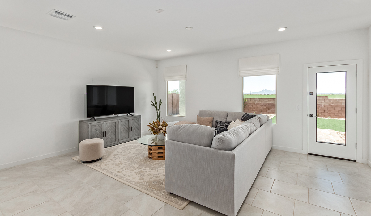 Step into The Kingston at Barnett Village, Marana, Arizona – a perfect blend of comfort, modern living, and energy efficiency. This thoughtfully crafted one-story home spans 2,068 square feet and offers four bedrooms and two bathrooms, ideal for families of all sizes.  The open-concept design features a spacious great room that effortlessly connects with the kitchen and dining area, creating an inviting central hub for everyday living and entertaining. The kitchen is equipped with contemporary appliances and a pantry, offering ample storage and convenience for meal preparation.  The primary bedroom, located at the rear of the home, provides a peaceful retreat with a private ensuite bathroom and a generous walk-in closet. The additional three bedrooms are positioned at the front of the house, offering versatility for use as guest rooms, a home office, or children’s bedrooms. Step outside to the covered patio, a perfect spot to enjoy the beautiful Arizona weather, whether for morning coffee or evening relaxation.  The Kingston also boasts a covered patio, perfect for enjoying Arizona’s beautiful desert evenings. Whether it’s morning coffee or evening relaxation, this outdoor space extends your living area into the serene landscape of Barnett Village.  Built with energy efficiency as a priority, the Kingston includes smart home technology, which not only simplifies daily living but also helps reduce utility costs. A two-car garage provides ample parking and additional storage space, enhancing the home’s functionality.