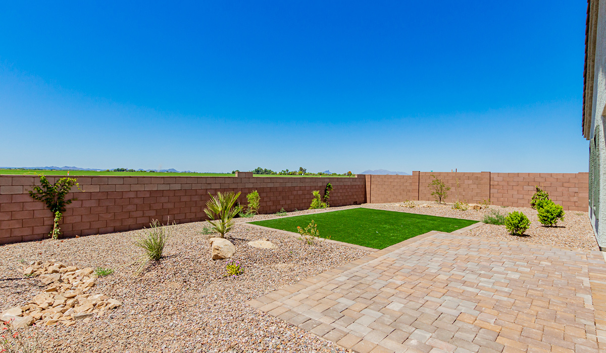 Step into The Kingston at Barnett Village, Marana, Arizona – a perfect blend of comfort, modern living, and energy efficiency. This thoughtfully crafted one-story home spans 2,068 square feet and offers four bedrooms and two bathrooms, ideal for families of all sizes.  The open-concept design features a spacious great room that effortlessly connects with the kitchen and dining area, creating an inviting central hub for everyday living and entertaining. The kitchen is equipped with contemporary appliances and a pantry, offering ample storage and convenience for meal preparation.  The primary bedroom, located at the rear of the home, provides a peaceful retreat with a private ensuite bathroom and a generous walk-in closet. The additional three bedrooms are positioned at the front of the house, offering versatility for use as guest rooms, a home office, or children’s bedrooms. Step outside to the covered patio, a perfect spot to enjoy the beautiful Arizona weather, whether for morning coffee or evening relaxation.  The Kingston also boasts a covered patio, perfect for enjoying Arizona’s beautiful desert evenings. Whether it’s morning coffee or evening relaxation, this outdoor space extends your living area into the serene landscape of Barnett Village.  Built with energy efficiency as a priority, the Kingston includes smart home technology, which not only simplifies daily living but also helps reduce utility costs. A two-car garage provides ample parking and additional storage space, enhancing the home’s functionality.