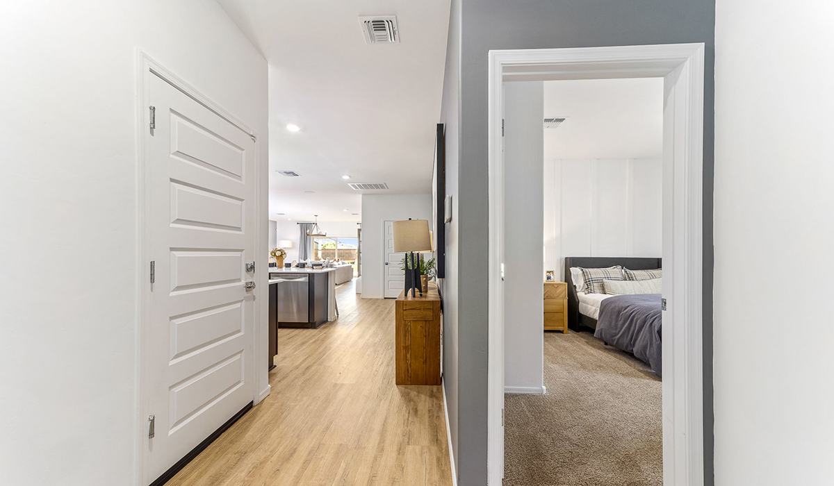 Step into The Kingston at Barnett Village, Marana, Arizona – a perfect blend of comfort, modern living, and energy efficiency. This thoughtfully crafted one-story home spans 2,068 square feet and offers four bedrooms and two bathrooms, ideal for families of all sizes.  The open-concept design features a spacious great room that effortlessly connects with the kitchen and dining area, creating an inviting central hub for everyday living and entertaining. The kitchen is equipped with contemporary appliances and a pantry, offering ample storage and convenience for meal preparation.  The primary bedroom, located at the rear of the home, provides a peaceful retreat with a private ensuite bathroom and a generous walk-in closet. The additional three bedrooms are positioned at the front of the house, offering versatility for use as guest rooms, a home office, or children’s bedrooms. Step outside to the covered patio, a perfect spot to enjoy the beautiful Arizona weather, whether for morning coffee or evening relaxation.  The Kingston also boasts a covered patio, perfect for enjoying Arizona’s beautiful desert evenings. Whether it’s morning coffee or evening relaxation, this outdoor space extends your living area into the serene landscape of Barnett Village.  Built with energy efficiency as a priority, the Kingston includes smart home technology, which not only simplifies daily living but also helps reduce utility costs. A two-car garage provides ample parking and additional storage space, enhancing the home’s functionality.  Images shown are for reference only. They depict the sales model home and may not represent the actual home.