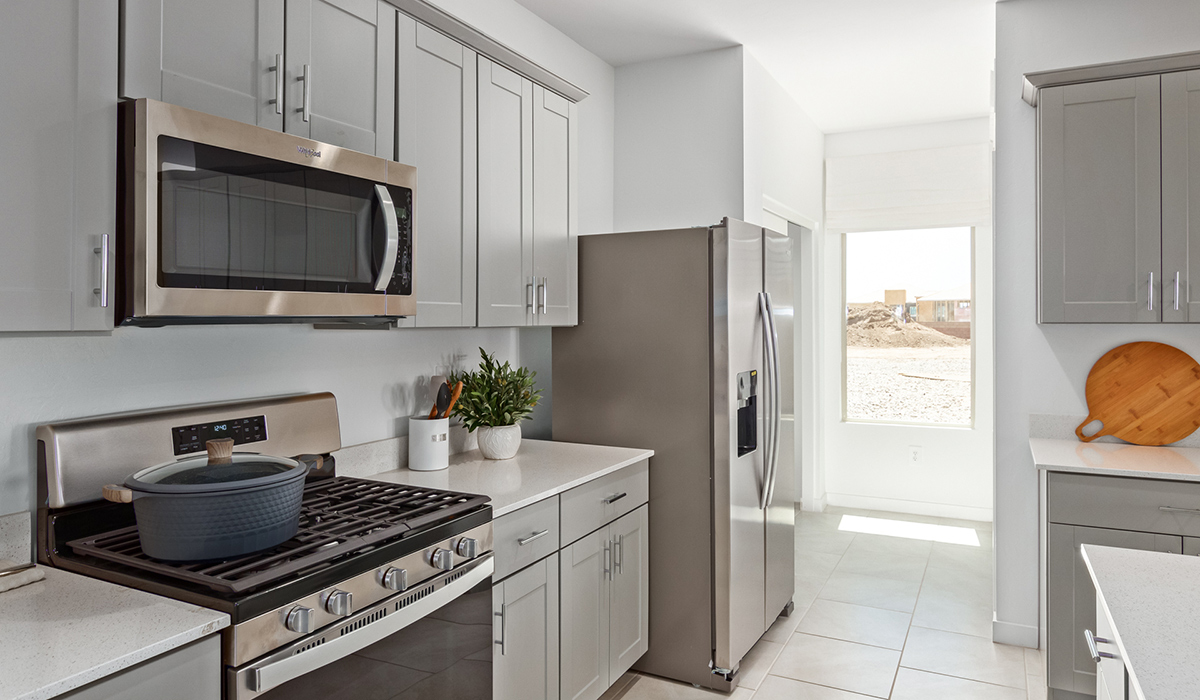 Step into The Kingston at Barnett Village, Marana, Arizona – a perfect blend of comfort, modern living, and energy efficiency. This thoughtfully crafted one-story home spans 2,068 square feet and offers four bedrooms and two bathrooms, ideal for families of all sizes.  The open-concept design features a spacious great room that effortlessly connects with the kitchen and dining area, creating an inviting central hub for everyday living and entertaining. The kitchen is equipped with contemporary appliances and a pantry, offering ample storage and convenience for meal preparation.  The primary bedroom, located at the rear of the home, provides a peaceful retreat with a private ensuite bathroom and a generous walk-in closet. The additional three bedrooms are positioned at the front of the house, offering versatility for use as guest rooms, a home office, or children’s bedrooms. Step outside to the covered patio, a perfect spot to enjoy the beautiful Arizona weather, whether for morning coffee or evening relaxation.  The Kingston also boasts a covered patio, perfect for enjoying Arizona’s beautiful desert evenings. Whether it’s morning coffee or evening relaxation, this outdoor space extends your living area into the serene landscape of Barnett Village.  Built with energy efficiency as a priority, the Kingston includes smart home technology, which not only simplifies daily living but also helps reduce utility costs. A two-car garage provides ample parking and additional storage space, enhancing the home’s functionality.