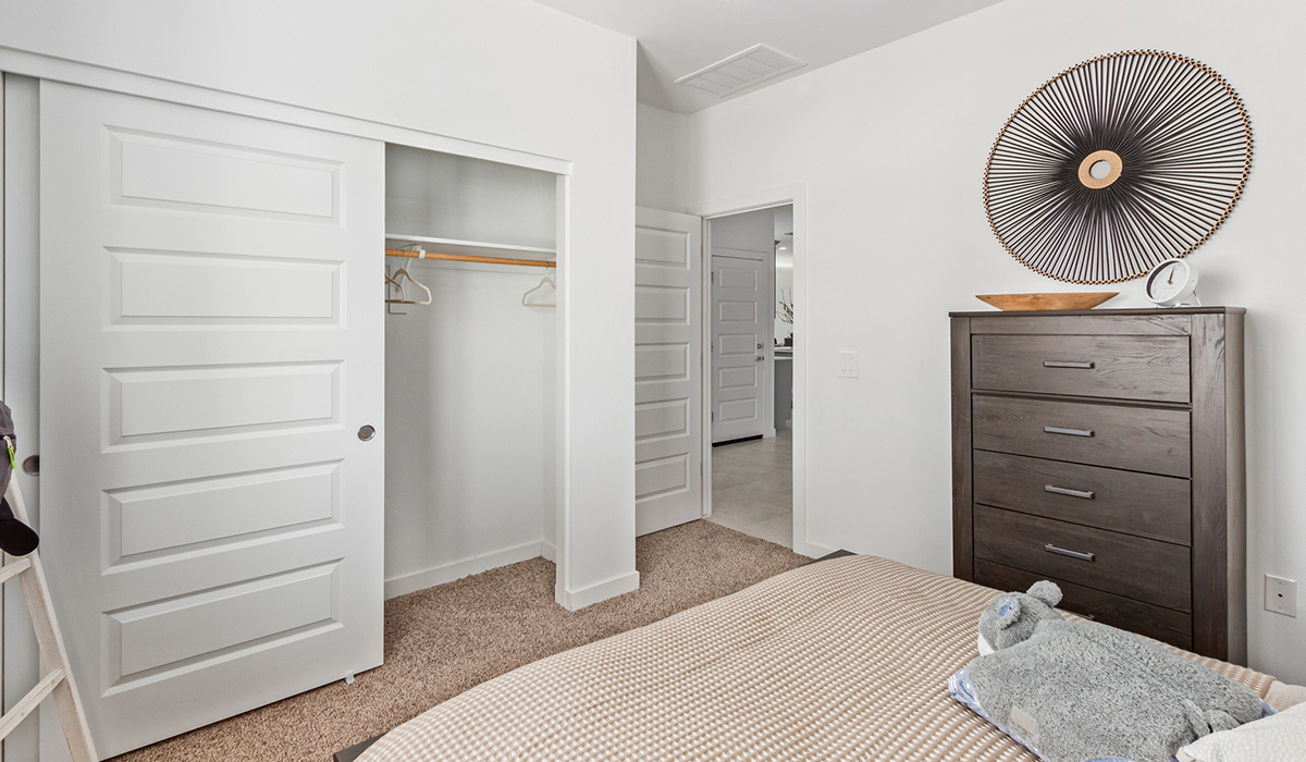 Step into The Kingston at Barnett Village, Marana, Arizona – a perfect blend of comfort, modern living, and energy efficiency. This thoughtfully crafted one-story home spans 2,068 square feet and offers four bedrooms and two bathrooms, ideal for families of all sizes.  The open-concept design features a spacious great room that effortlessly connects with the kitchen and dining area, creating an inviting central hub for everyday living and entertaining. The kitchen is equipped with contemporary appliances and a pantry, offering ample storage and convenience for meal preparation.  The primary bedroom, located at the rear of the home, provides a peaceful retreat with a private ensuite bathroom and a generous walk-in closet. The additional three bedrooms are positioned at the front of the house, offering versatility for use as guest rooms, a home office, or children’s bedrooms. Step outside to the covered patio, a perfect spot to enjoy the beautiful Arizona weather, whether for morning coffee or evening relaxation.  The Kingston also boasts a covered patio, perfect for enjoying Arizona’s beautiful desert evenings. Whether it’s morning coffee or evening relaxation, this outdoor space extends your living area into the serene landscape of Barnett Village.  Built with energy efficiency as a priority, the Kingston includes smart home technology, which not only simplifies daily living but also helps reduce utility costs. A two-car garage provides ample parking and additional storage space, enhancing the home’s functionality.