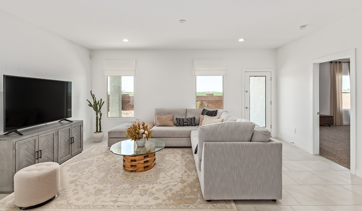 Step into The Kingston at Barnett Village, Marana, Arizona – a perfect blend of comfort, modern living, and energy efficiency. This thoughtfully crafted one-story home spans 2,068 square feet and offers four bedrooms and two bathrooms, ideal for families of all sizes.  The open-concept design features a spacious great room that effortlessly connects with the kitchen and dining area, creating an inviting central hub for everyday living and entertaining. The kitchen is equipped with contemporary appliances and a pantry, offering ample storage and convenience for meal preparation.  The primary bedroom, located at the rear of the home, provides a peaceful retreat with a private ensuite bathroom and a generous walk-in closet. The additional three bedrooms are positioned at the front of the house, offering versatility for use as guest rooms, a home office, or children’s bedrooms. Step outside to the covered patio, a perfect spot to enjoy the beautiful Arizona weather, whether for morning coffee or evening relaxation.  The Kingston also boasts a covered patio, perfect for enjoying Arizona’s beautiful desert evenings. Whether it’s morning coffee or evening relaxation, this outdoor space extends your living area into the serene landscape of Barnett Village.  Built with energy efficiency as a priority, the Kingston includes smart home technology, which not only simplifies daily living but also helps reduce utility costs. A two-car garage provides ample parking and additional storage space, enhancing the home’s functionality.