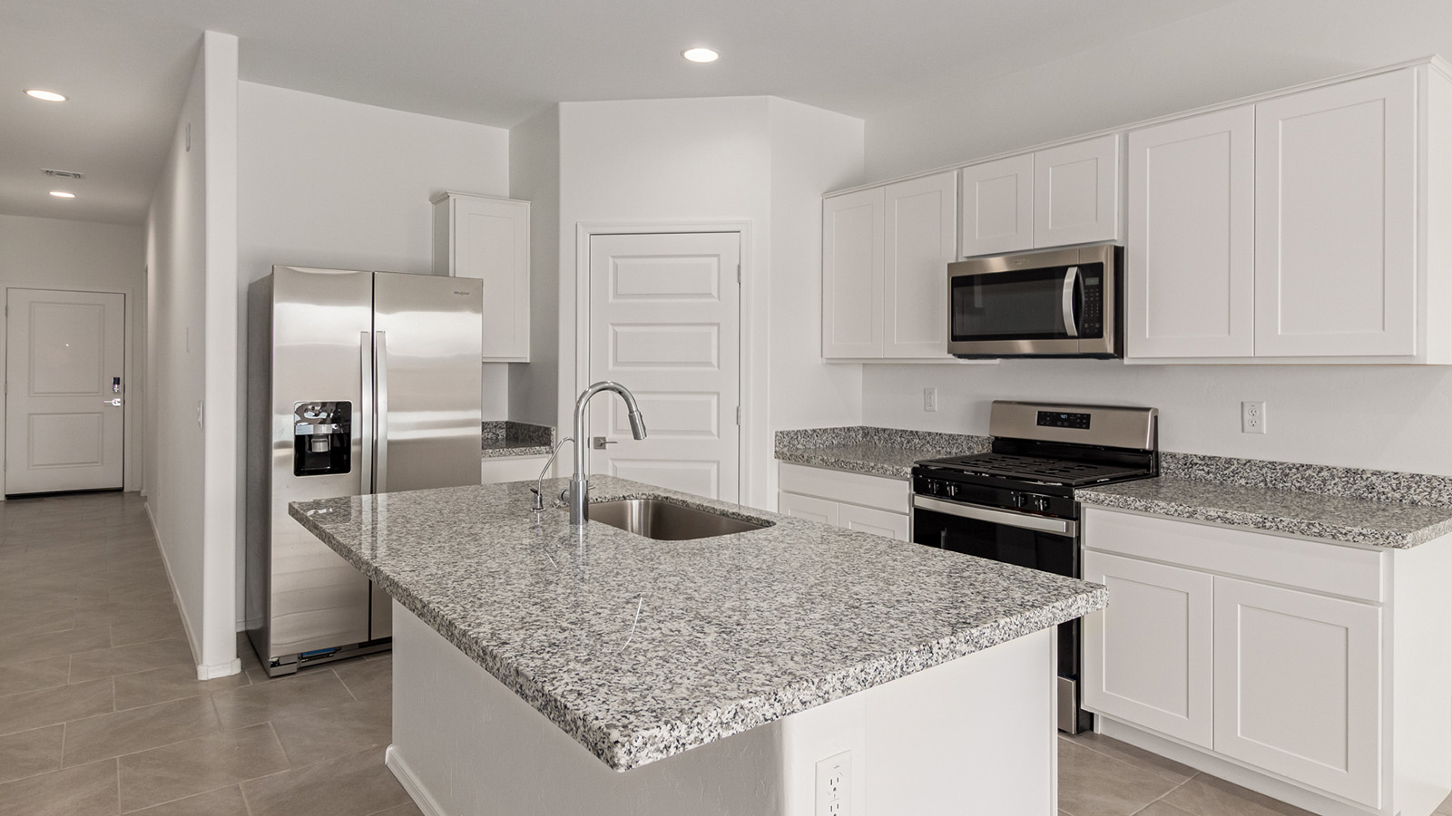 Discover The Easton at Barnett Village in Marana, Arizona – a spacious 1,701 sq. ft. single-story new home designed to offer both style and functionality for today’s modern family.  As you enter through the charming front porch, you’re welcomed into a thoughtful layout that makes every square foot count. Situated near the entrance you'll find the first bedroom, offering flexibility as a guest room, home office, or a cozy retreat.  Continuing down the hall, you’re led into the expansive great room, which flows seamlessly into the dining area and kitchen. This open-concept design ensures that the heart of the home is always connected, whether you’re preparing meals, dining, or relaxing with loved ones. The kitchen features sleek quartz countertops, a spacious center island, modern appliances, and a walk-in pantry that offers ample storage for all your cooking essentials.  The great room opens up to a covered patio, an ideal space to unwind and enjoy Arizona’s beautiful desert sunsets. Whether you’re hosting a weekend barbecue or enjoying a quiet evening outdoors, this patio extends your living space into the scenic surroundings of Barnett Village.  Just off the great room, a private hallway leads to the primary bedroom, which is a true retreat within the home. The primary suite is generously sized and includes a large walk-in closet and an en-suite bathroom, offering both luxury and convenience.   The Easton also features two additional bedrooms, well-positioned to share a full bathroom. These rooms are ideal for family members, providing comfortable living spaces with plenty of natural light.  For added convenience, the home includes a utility room and direct access to a two-car garage, making daily routines smoother and more efficient.  Designed with energy efficiency in mind, The Easton at Barnett Village is DOE Zero Energy Ready Home certified, ensuring both sustainability and savings.