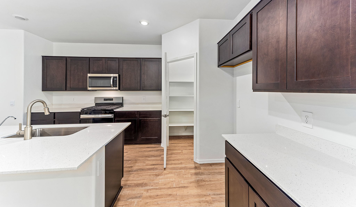 Step into The Dalea at Barnett Village, Marana, Arizona – a perfect blend of comfort, modern living, and energy efficiency. This thoughtfully crafted one-story home spans 2,224 square feet and offers five bedrooms and 3 bathrooms, ideal for families of all sizes.  The open-concept design features a spacious great room that effortlessly connects with the kitchen and dining area, creating an inviting central hub for everyday living and entertaining. The kitchen is equipped with contemporary appliances and a pantry, offering ample storage and convenience for meal preparation.  The primary bedroom, located at the rear of the home, provides a peaceful retreat with a private ensuite bathroom and a generous walk-in closet. The additional four bedrooms are positioned at the front of the house, offering versatility for use as guest rooms, a home office, or children’s bedrooms.  The Dalea floor plan offers the option of a three-car tandem garage, perfect for additional space and larger sized vehicles. Whether it’s morning coffee or evening relaxation, this outdoor space extends your living area into the serene landscape of Barnett Village.  Built with energy efficiency as a priority, the Dalea includes smart home technology, which not only simplifies daily living but also helps reduce utility costs.