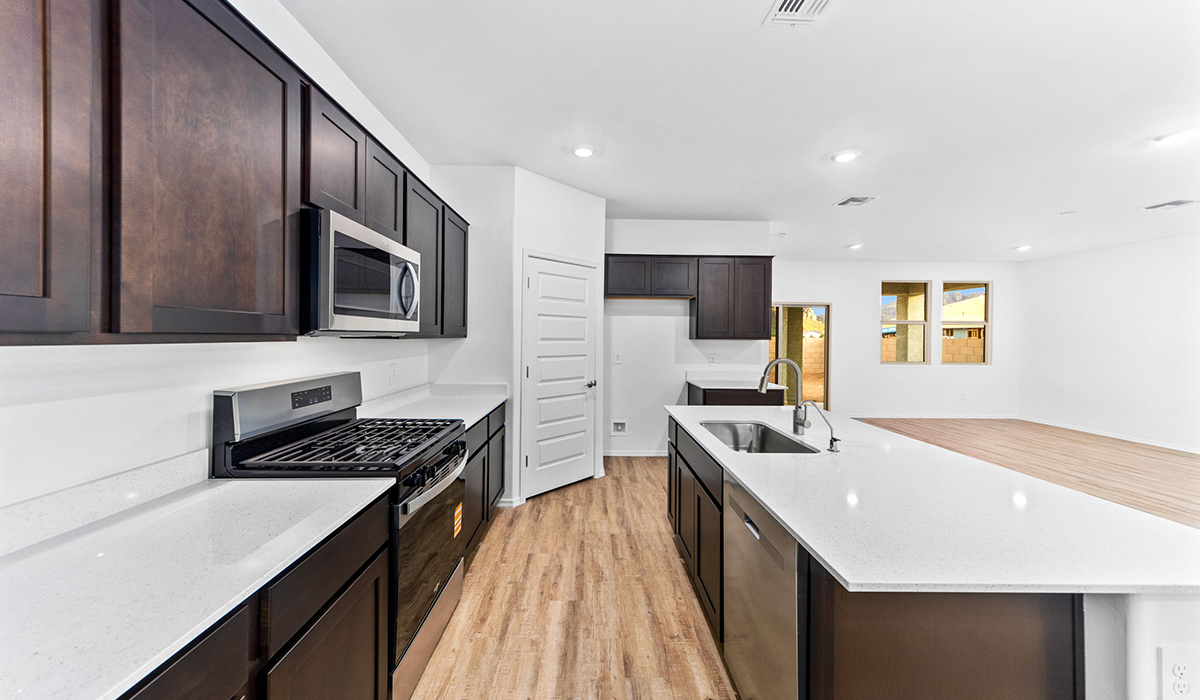 Step into The Dalea at Barnett Village, Marana, Arizona – a perfect blend of comfort, modern living, and energy efficiency. This thoughtfully crafted one-story home spans 2,224 square feet and offers five bedrooms and 3 bathrooms, ideal for families of all sizes.  The open-concept design features a spacious great room that effortlessly connects with the kitchen and dining area, creating an inviting central hub for everyday living and entertaining. The kitchen is equipped with contemporary appliances and a pantry, offering ample storage and convenience for meal preparation.  The primary bedroom, located at the rear of the home, provides a peaceful retreat with a private ensuite bathroom and a generous walk-in closet. The additional four bedrooms are positioned at the front of the house, offering versatility for use as guest rooms, a home office, or children’s bedrooms.  The Dalea floor plan offers the option of a three-car tandem garage, perfect for additional space and larger sized vehicles. Whether it’s morning coffee or evening relaxation, this outdoor space extends your living area into the serene landscape of Barnett Village.  Built with energy efficiency as a priority, the Dalea includes smart home technology, which not only simplifies daily living but also helps reduce utility costs.