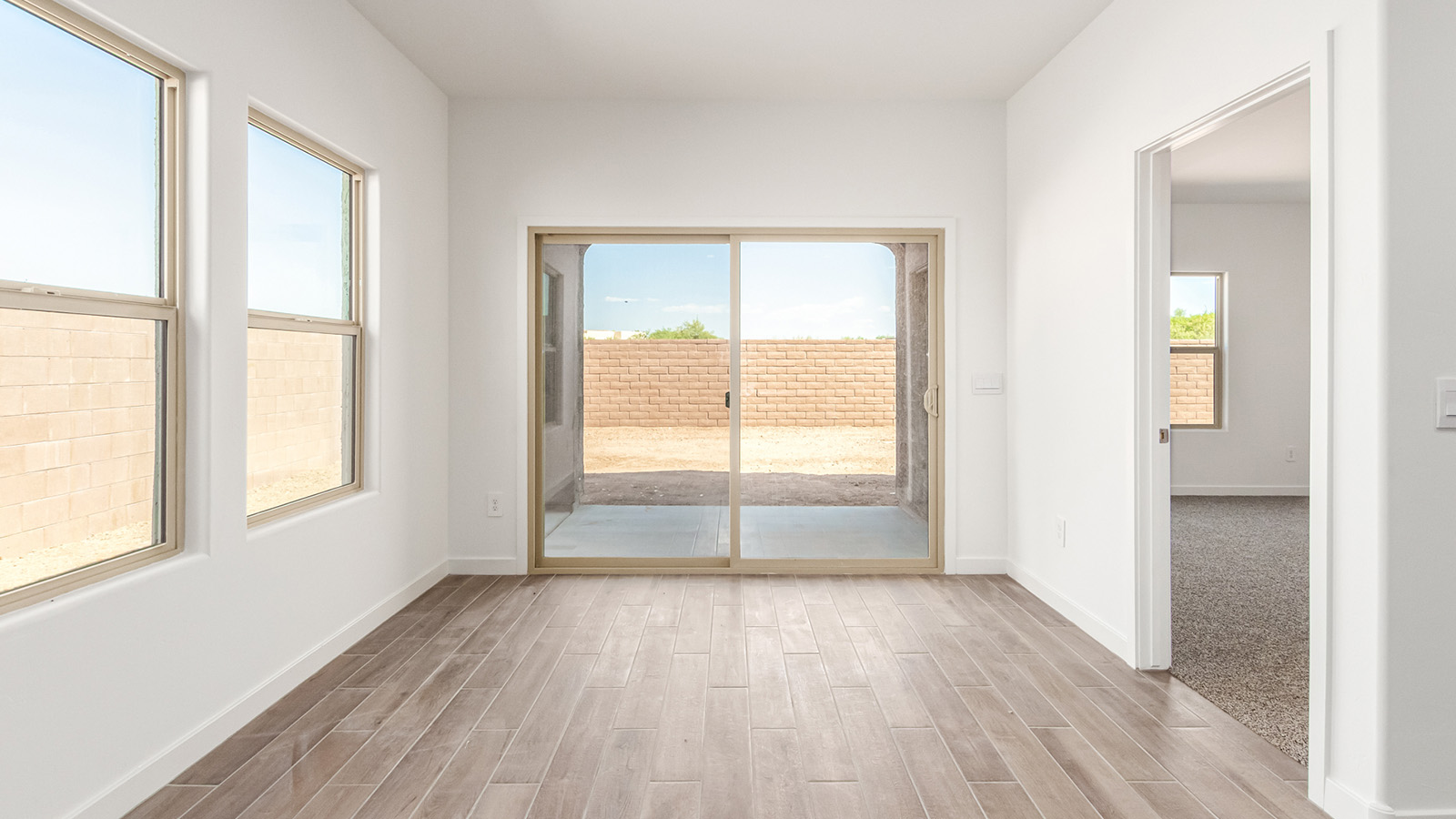 Step into The Baxter at Barnett Village, Marana, Arizona – a beautifully designed 1,423 sq. ft. single-story new home that seamlessly blends modern comfort with thoughtful functionality.  As you enter through the welcoming front porch, you're greeted by an inviting entryway that leads directly into the heart of the home – a spacious and open-concept great room. This area flows effortlessly into the dining space, creating an ideal setting for family gatherings and entertaining guests.  The gourmet kitchen, adjacent to the dining room, features elegant granite countertops, a large island with a breakfast bar, and a walk-in pantry. It’s a space where culinary creativity meets convenience, complete with modern appliances and plenty of storage.  Tucked away in the rear of the home is the master suite, offering privacy and comfort. The suite includes a generous walk-in closet and a luxurious en-suite bathroom with dual vanities and a walk-in shower. Large windows let in plenty of natural light, creating a serene retreat within the home.  Two additional bedrooms are located toward the front of the house, each with easy access to a full bathroom. These rooms are perfect for family, guests, or even a home office.  The Baxter also boasts a covered patio, perfect for enjoying Arizona’s beautiful desert evenings. Whether it’s morning coffee or evening relaxation, this outdoor space extends your living area into the serene landscape of Barnett Village.  With a two-car garage and energy-efficient features that include DOE Zero Energy Ready Home certification, The Baxter at Barnett Village offers not just a home, but a lifestyle that emphasizes comfort, sustainability, and convenience.  *Images shown are for reference only. They depict the Baxter model home and may not represent the actual home.