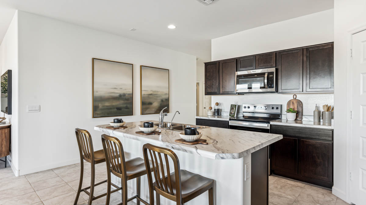 Explore The Denton at Barnett Village in Marana, Arizona – a spacious 1,615 sq. ft. single-story home designed to accommodate both comfort and convenience for modern living.  As you step through the front porch and into the welcoming entryway, you're immediately led into a thoughtfully designed space that maximizes every square foot. Near the front of the home, you’ll find two bedrooms and full bathroom.  Continuing through the home, you’ll enter the heart of The Denton – an expansive great room that seamlessly connects to the dining area and kitchen area. This open-concept space is perfect for entertaining or everyday family living, allowing for a fluid transition from cooking to dining to relaxation. The kitchen is equipped with sleek quartz countertops, modern appliances, a walk-in pantry, and an island that doubles as a breakfast bar, providing ample space for meal prep and casual dining.  Adjacent to the great room, you find the primary suite sanctuary with a large walk-in closet and an en-suite bathroom.   The Denton also includes a utility room that adds functionality and storage options to the home, as well as direct access to a two-car garage.  Step outside from the great room to the covered patio – a perfect spot to enjoy Arizona’s beautiful weather year-round, whether you’re sipping your morning coffee or hosting an evening barbecue.  Designed with energy efficiency in mind, The Dalton at Barnett Village is DOE Zero Energy Ready Home certified, ensuring long-term savings and a comfortable living environment.