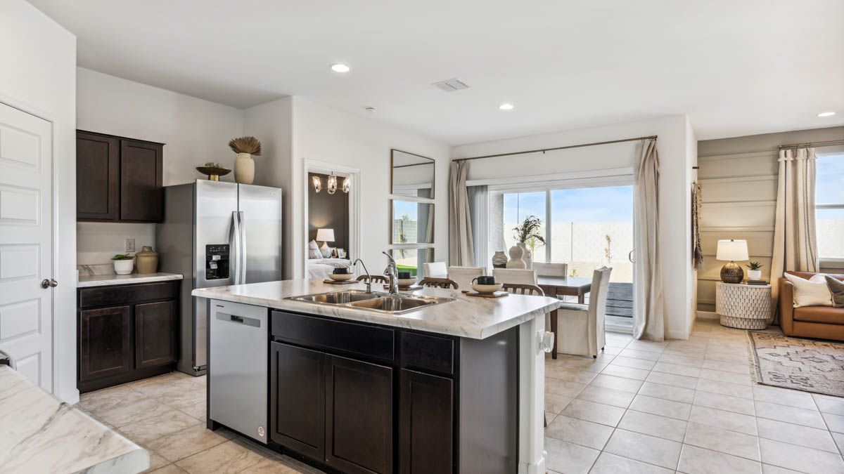 Explore The Denton at Barnett Village in Marana, Arizona – a spacious 1,615 sq. ft. single-story home designed to accommodate both comfort and convenience for modern living.  As you step through the front porch and into the welcoming entryway, you're immediately led into a thoughtfully designed space that maximizes every square foot. Near the front of the home, you’ll find two bedrooms and full bathroom.  Continuing through the home, you’ll enter the heart of The Denton – an expansive great room that seamlessly connects to the dining area and kitchen area. This open-concept space is perfect for entertaining or everyday family living, allowing for a fluid transition from cooking to dining to relaxation. The kitchen is equipped with sleek quartz countertops, modern appliances, a walk-in pantry, and an island that doubles as a breakfast bar, providing ample space for meal prep and casual dining.  Adjacent to the great room, you find the primary suite sanctuary with a large walk-in closet and an en-suite bathroom.   The Denton also includes a utility room that adds functionality and storage options to the home, as well as direct access to a two-car garage.  Step outside from the great room to the covered patio – a perfect spot to enjoy Arizona’s beautiful weather year-round, whether you’re sipping your morning coffee or hosting an evening barbecue.  Designed with energy efficiency in mind, The Dalton at Barnett Village is DOE Zero Energy Ready Home certified, ensuring long-term savings and a comfortable living environment.